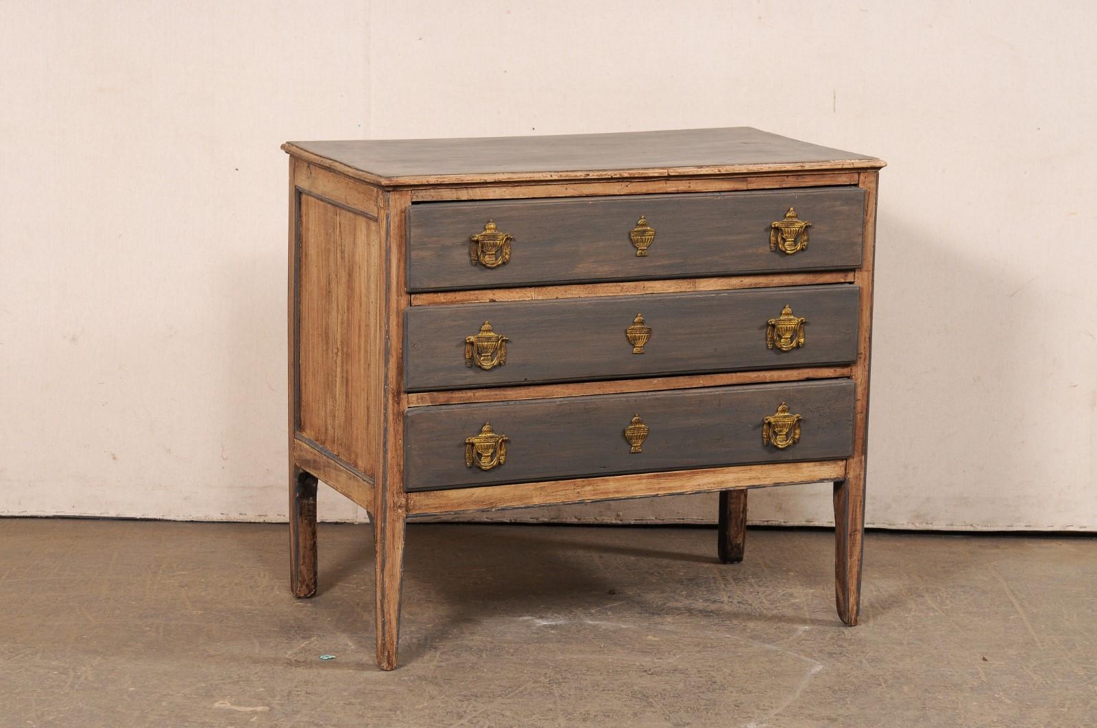 An Italian two-tone painted wood chest of drawers, with great Neoclassical hardware, from the turn of 18th and 19th century. This antique chest from Italy has a rectangular-shaped top which slightly overhangs the case beneath that houses three full