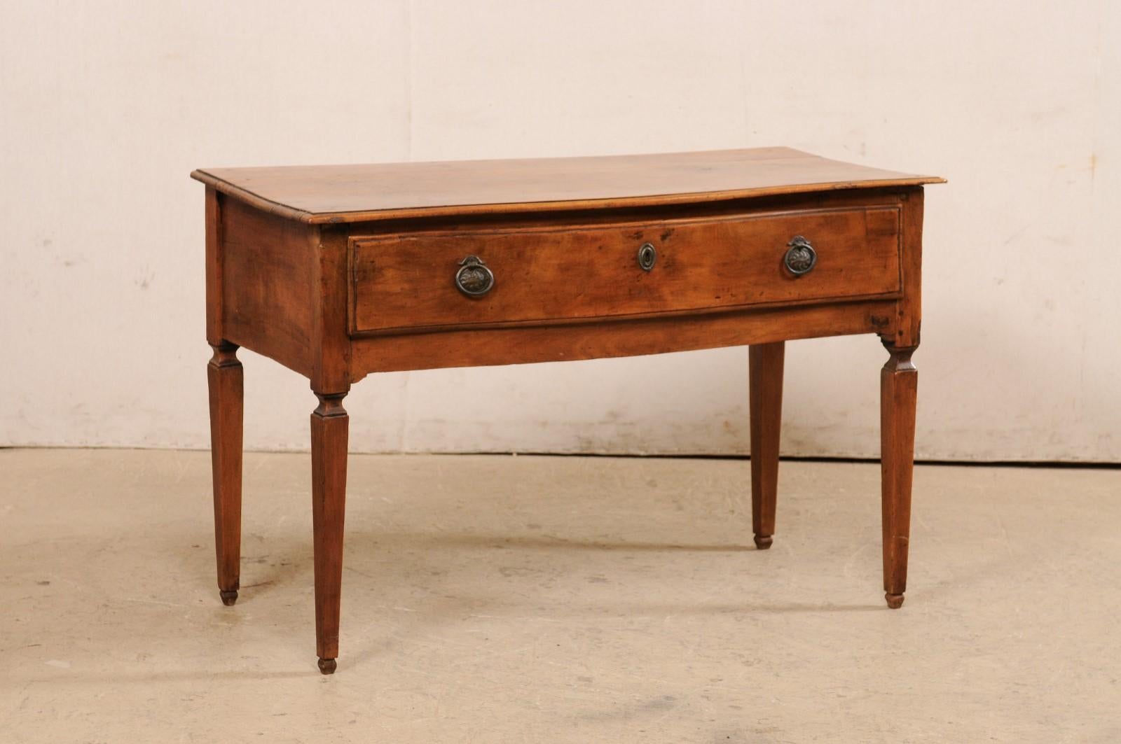 An Italian carved walnut console table, with subtle bow front and single drawer, from the turn of the 18th and 19th century. This antique table from Italy features a rectangular-shaped top which has a slightly bow-shaped front which overhangs and