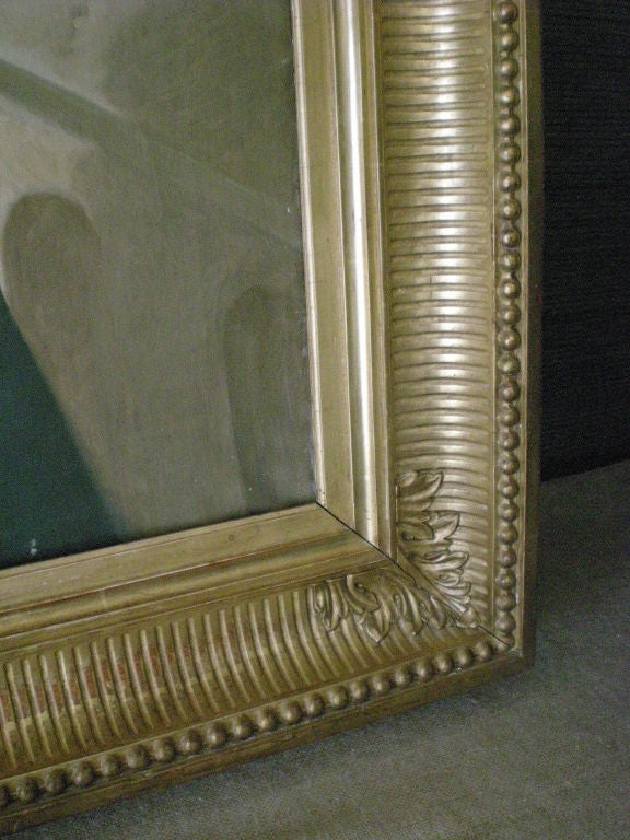 Portrait à l'huile sur toile d'une dame aristocrate à la manière de la Révolution française. Belle coloration et cadre doré d'origine avec cannelures et perles.