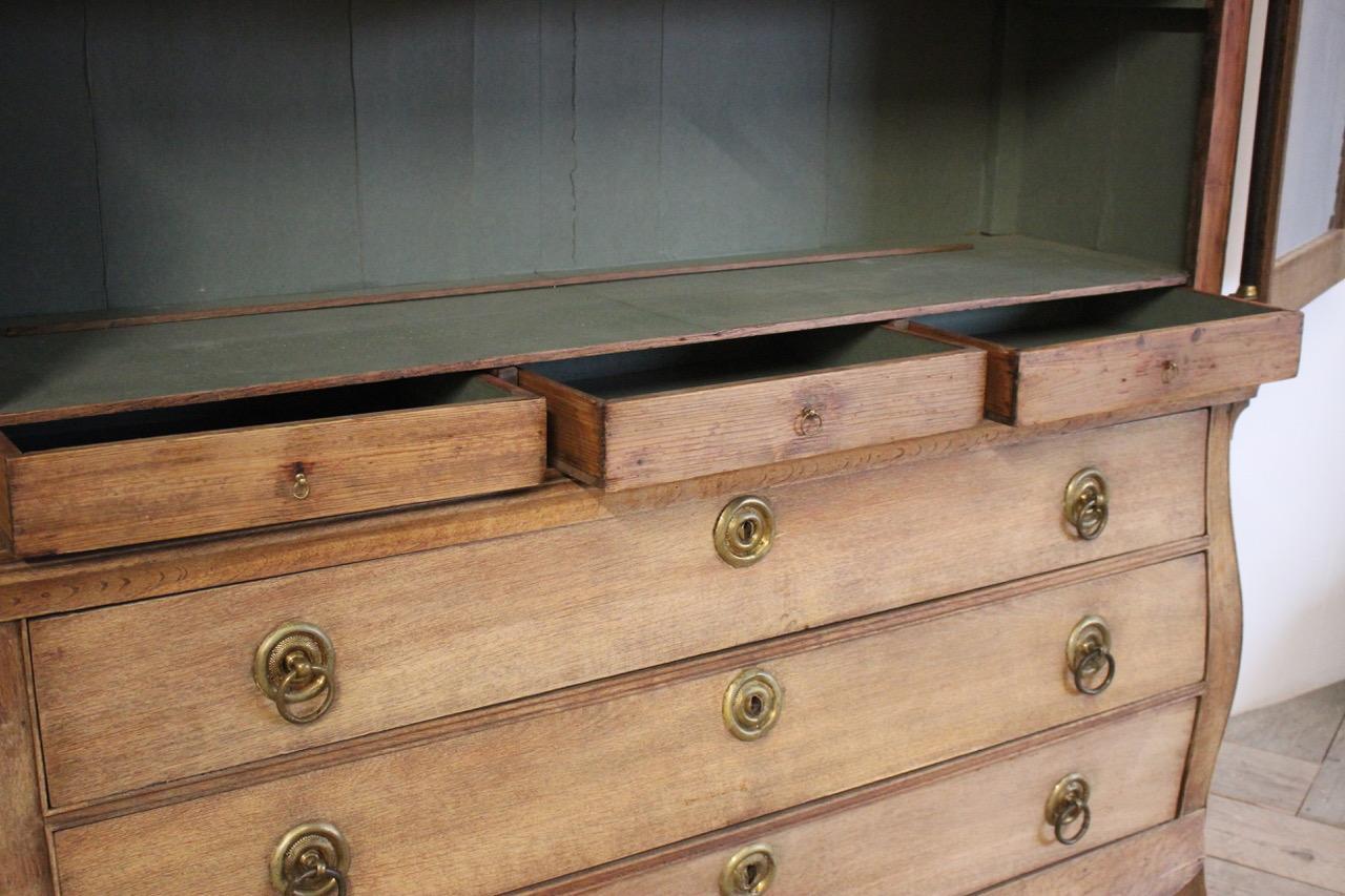 A late 18th century French Louis XVI display cabinet in bleached oak, the lower part with three drawers. The upper section with two glazed doors enclosing three smaller drawers and two fixed shelves.
All the interiors lined in blue paper.