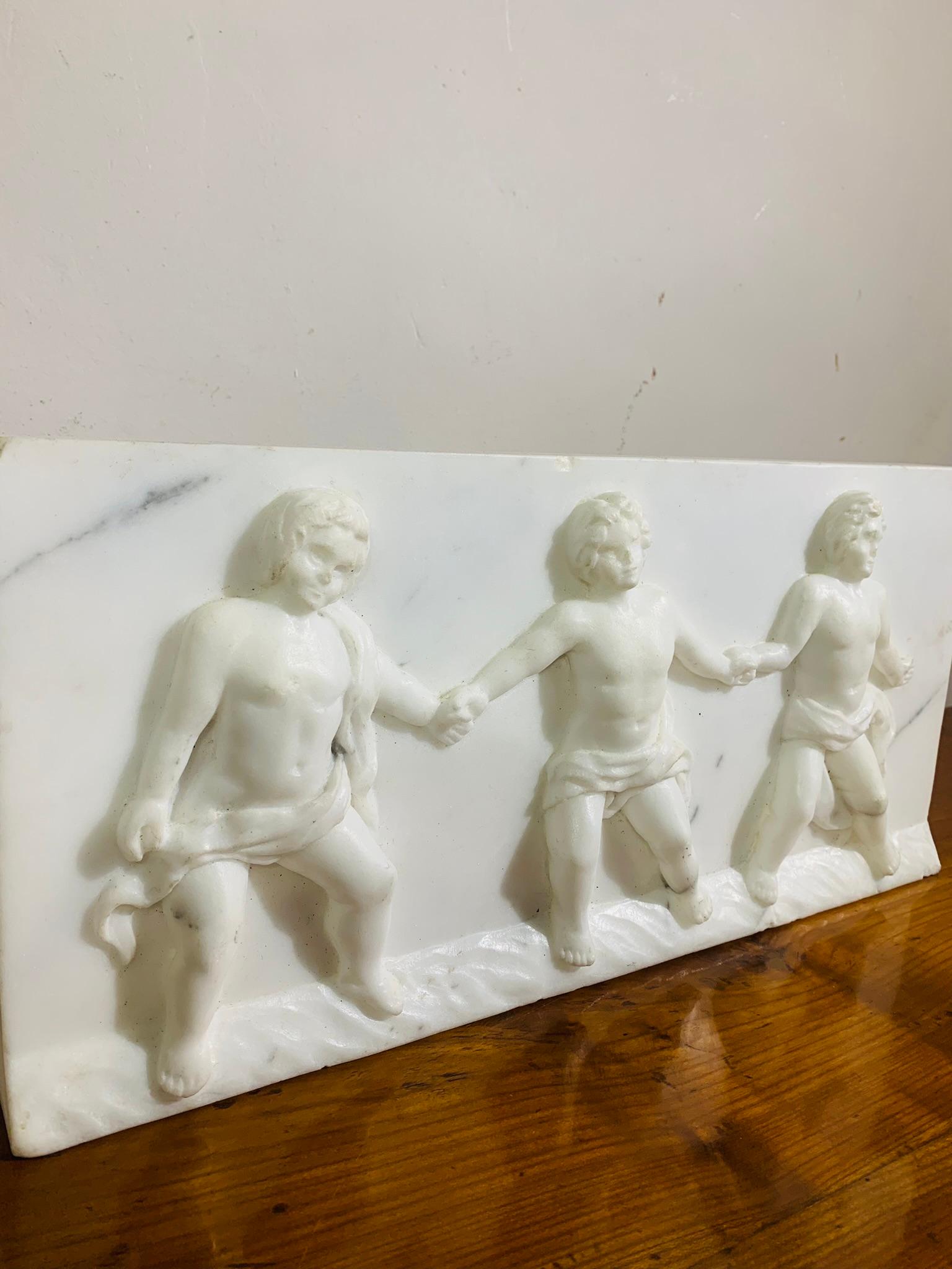 Beautiful bas-relief in white Carrara marble depicting the allegory of Friendship. It features three sculpted putti holding hands.
Slightly protruding base.
