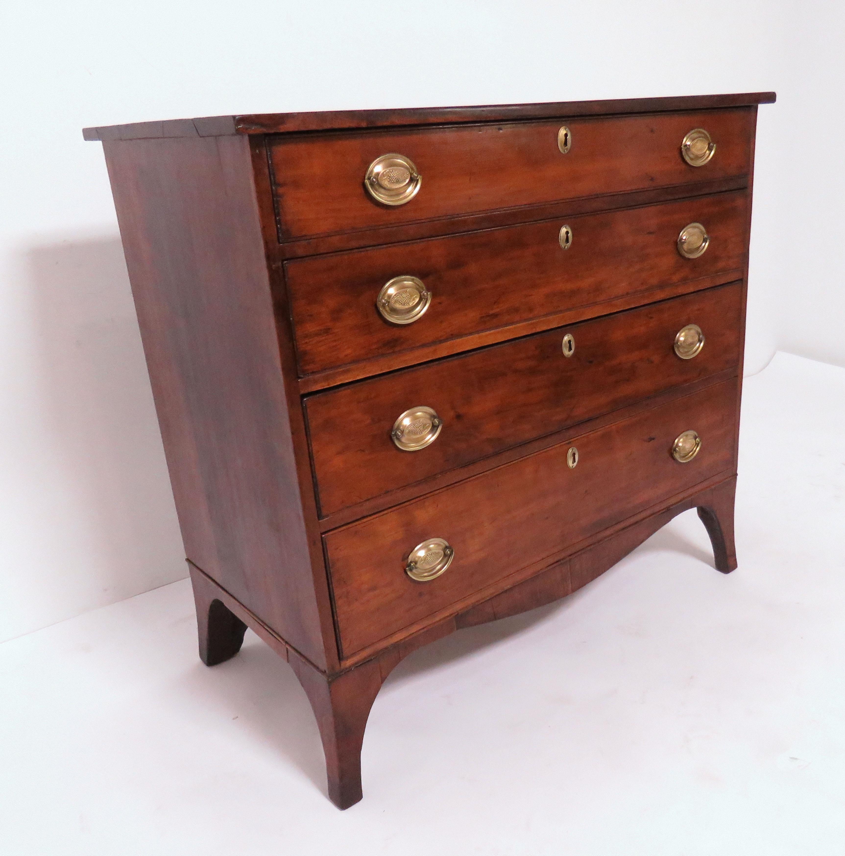 A late 18th century American Federal period, Hepplewhite chest of drawers in cherry and mahogany with splayed (French) bracket feet and original English brasses, from a New Hampshire estate.