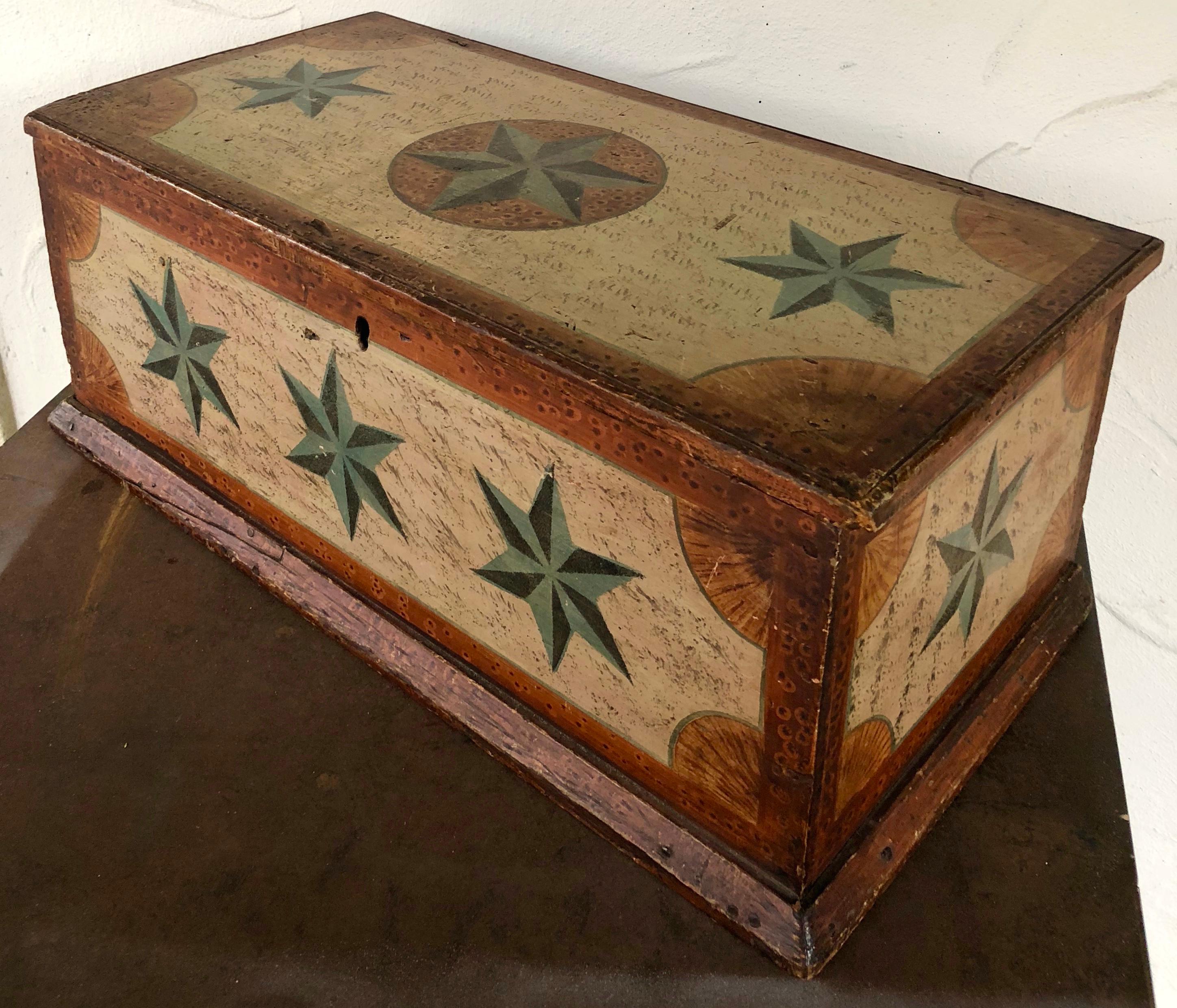 Great Folk Art paint decoration in the form of multiple compass stars. Appears to be constructed of pine, cotter pin hinges, some rose head and some square nails. It is partially lined with some 18th century newspaper. The paint decoration is early