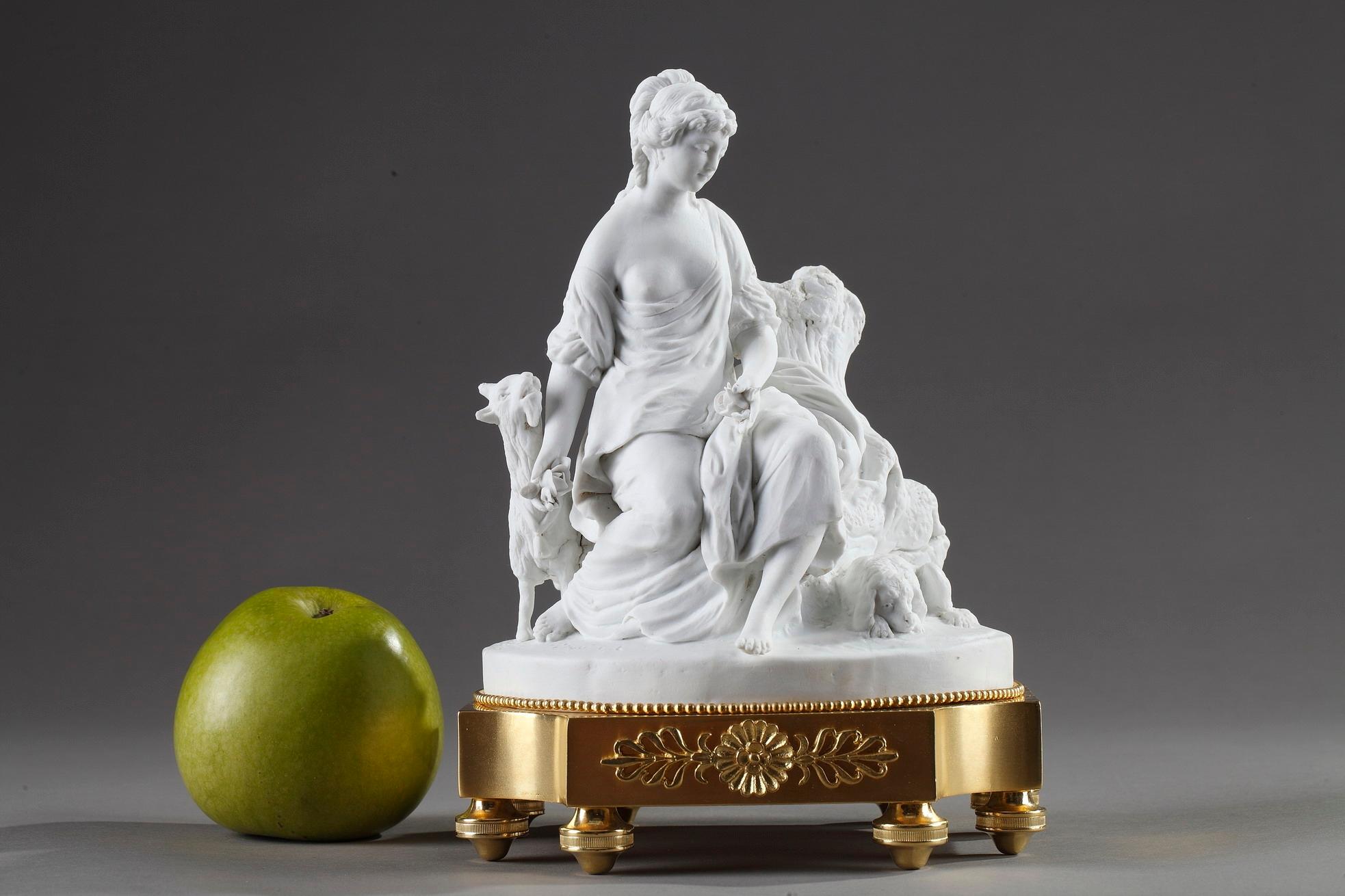 This enchanting late 18th century bisque porcelain group exhibits classical iconography and modern scene. Depicting a young shepherdess seated on a rock and accompanied by a goat and dog, this captivating figure reflects the deep passion for nature