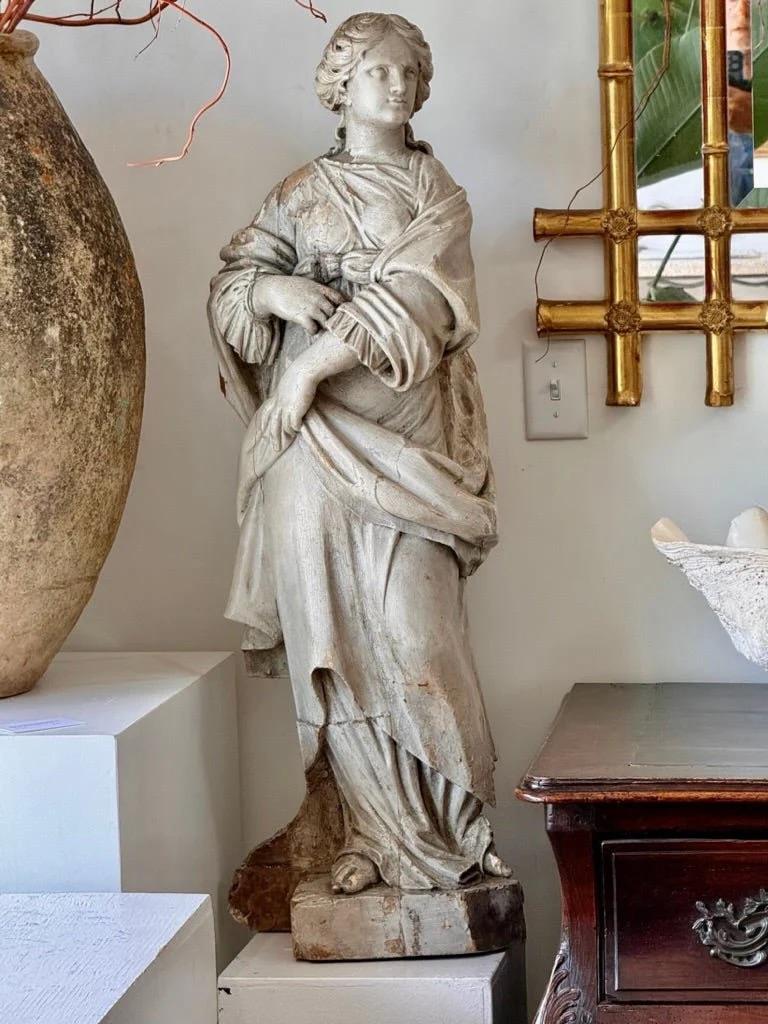 Statua francese della fine del XVIII secolo intagliata e policroma di colore bianco sporco raffigurante Santa Barbara, l'ispirazione per Rapunzel.