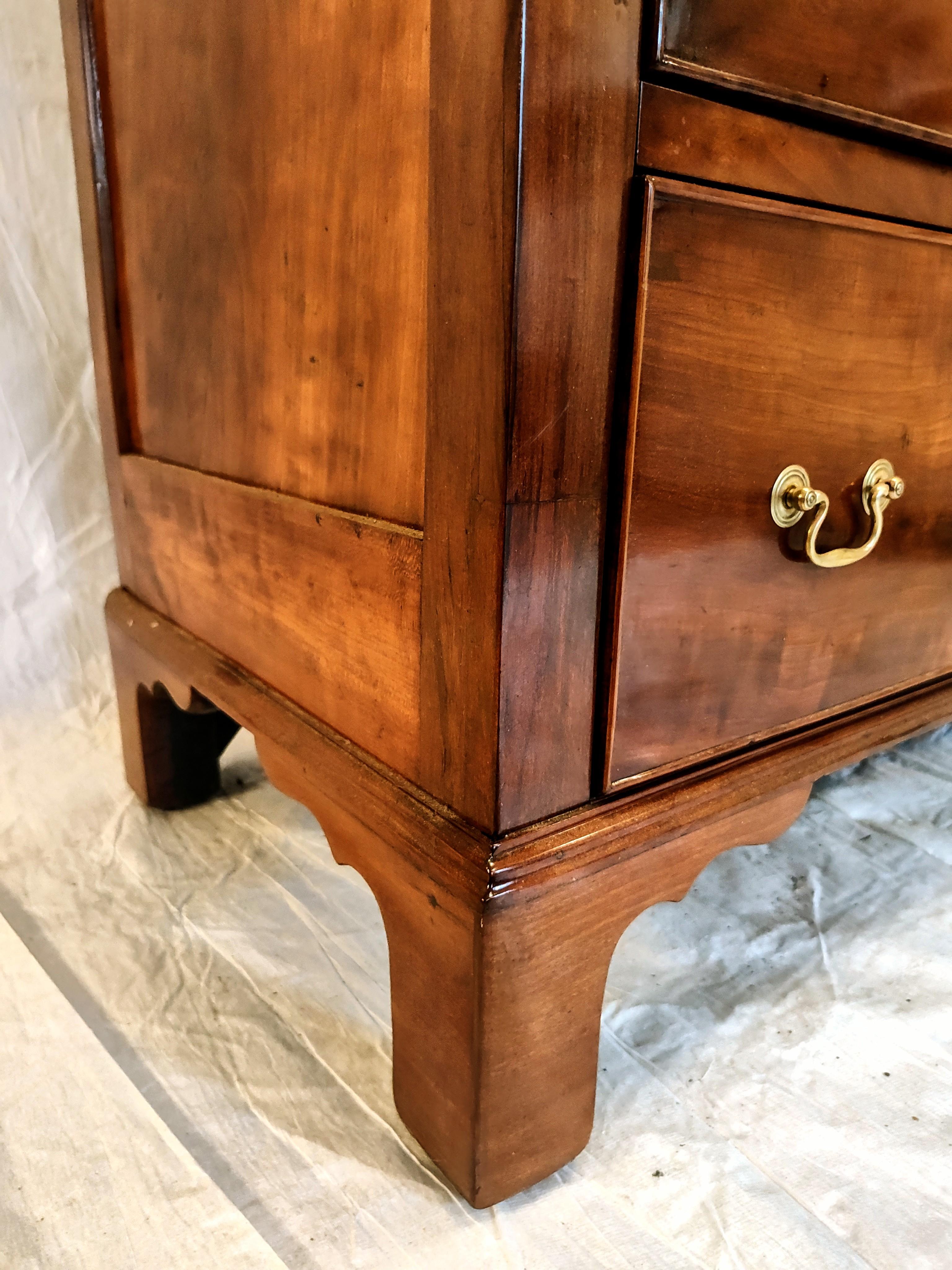Chippendale Cherry Wood Four Drawer Chest.Circa. 1770-80.  Features four graduated drawers, frame and panel construction sitting upon a tall bracket for base. The drawer fronts as well as the top are wonderfully figured and the whole chest has a