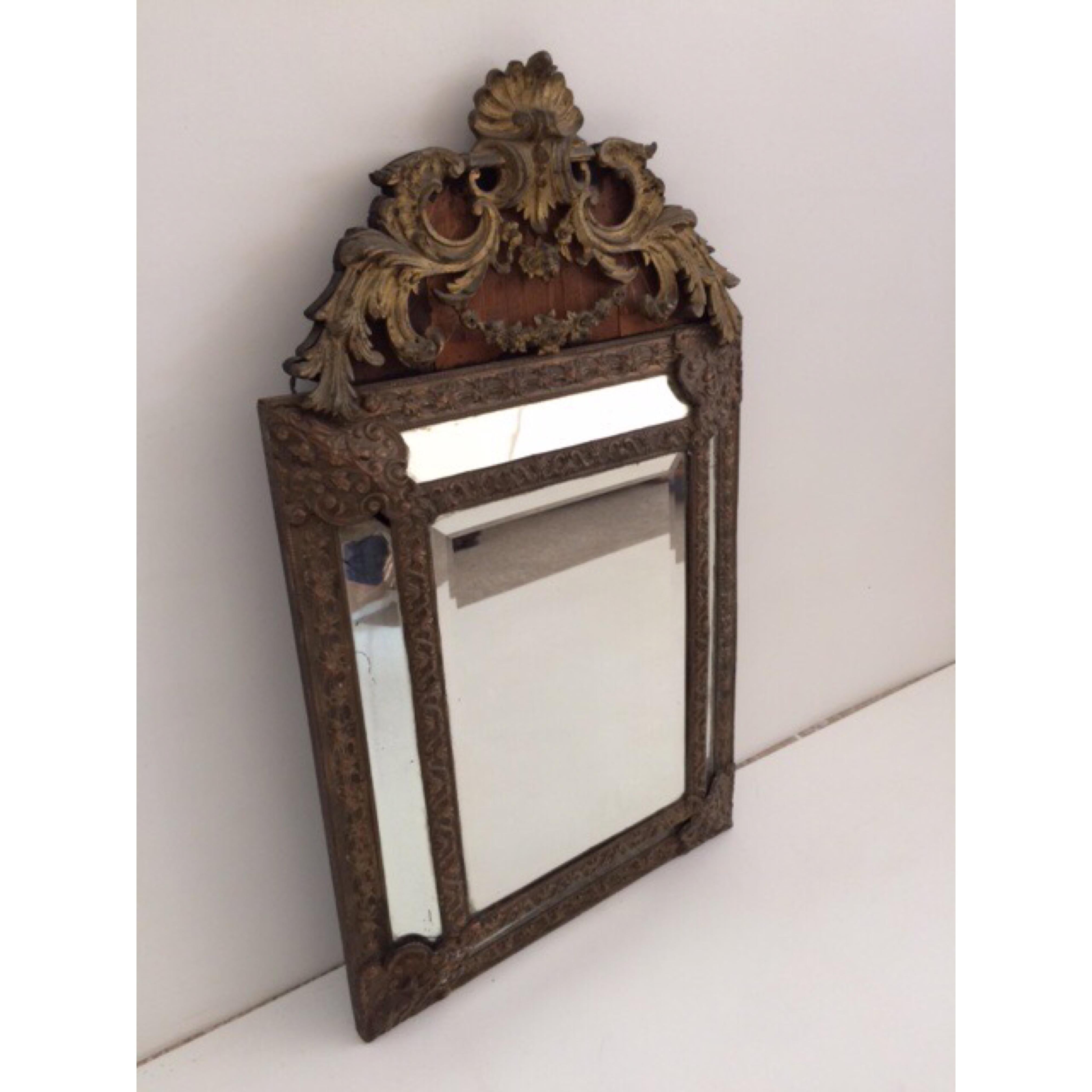Continental European mirror with gilt bronze top and additional gold leaf around mirror. Wood back.