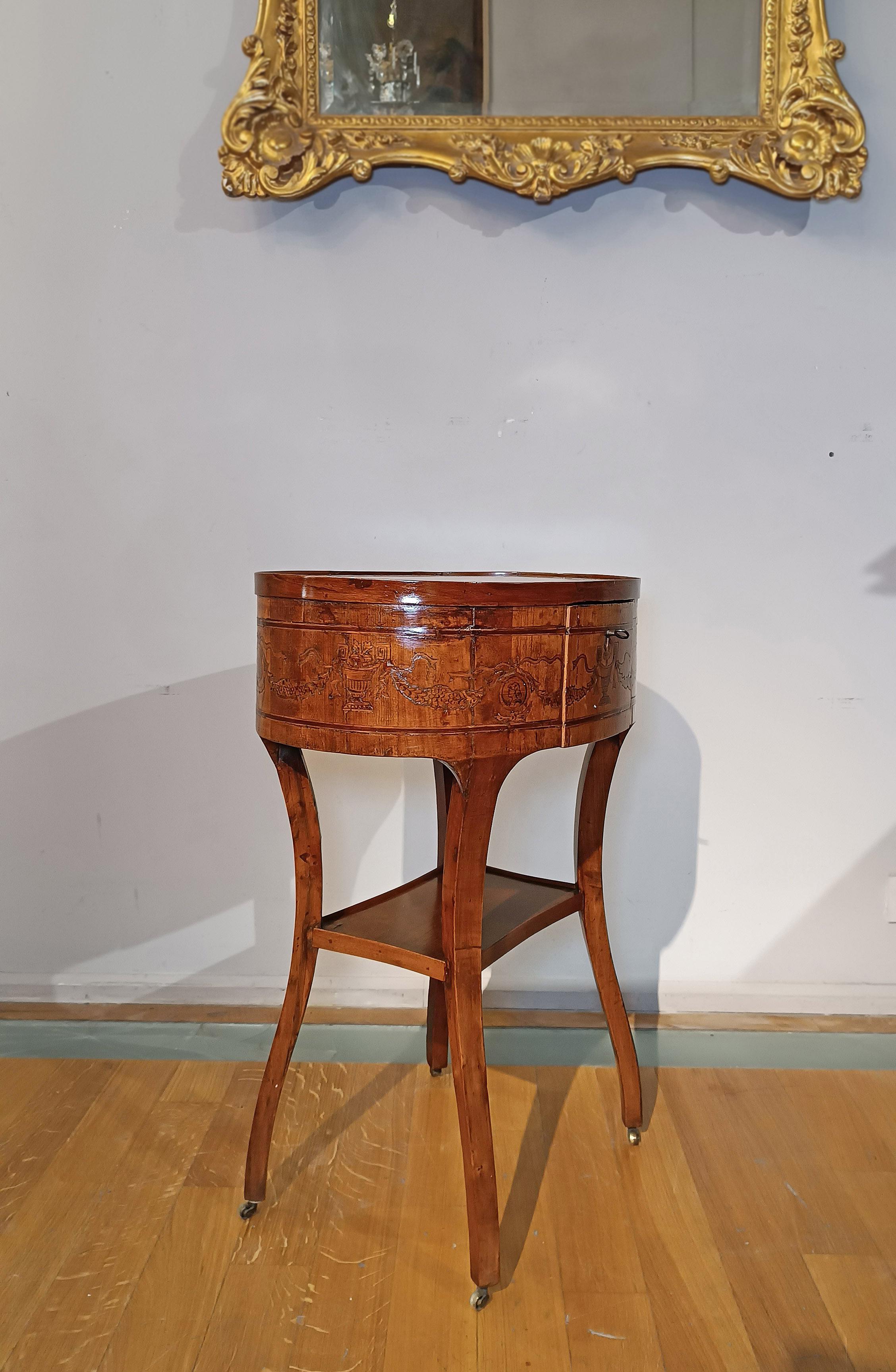 Élégante petite table d'appoint en cerisier et noyer sculpté, enrichie d'incrustations de pastilles ébonisées. Les incrustations, qui ornent à la fois le plateau et le bandeau de la sous-platine, présentent des motifs géométriques et floraux qui