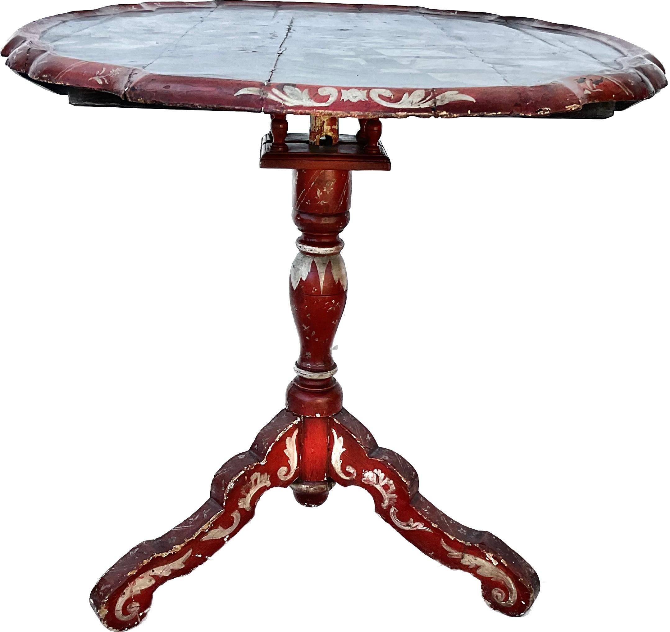 Dutch painted tilt top table with a dished oval marbleized top decorated with a scene of merrymakers frolicking in a theater. Red painted tripod Base and Bird Cage. Late 18th century Dutch, Ameland circa 1780.