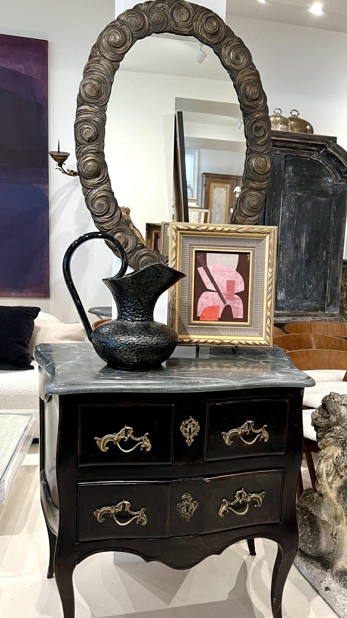 Grand miroir ovale avec un cadre en tole avec des formes de nuages tourbillonnants. Le charme.