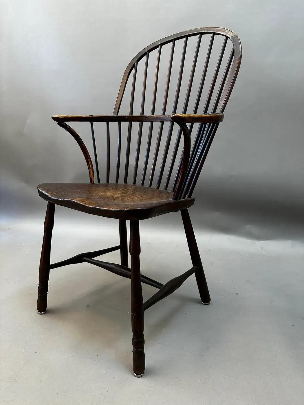 An exceptional 18th-century English Windsor armchair crafted in the Midlands, circa 1790. This classic example features a hooped back with finely turned spindles, shaped arms supported by slender crinoline stretchers, and well-turned front legs. The
