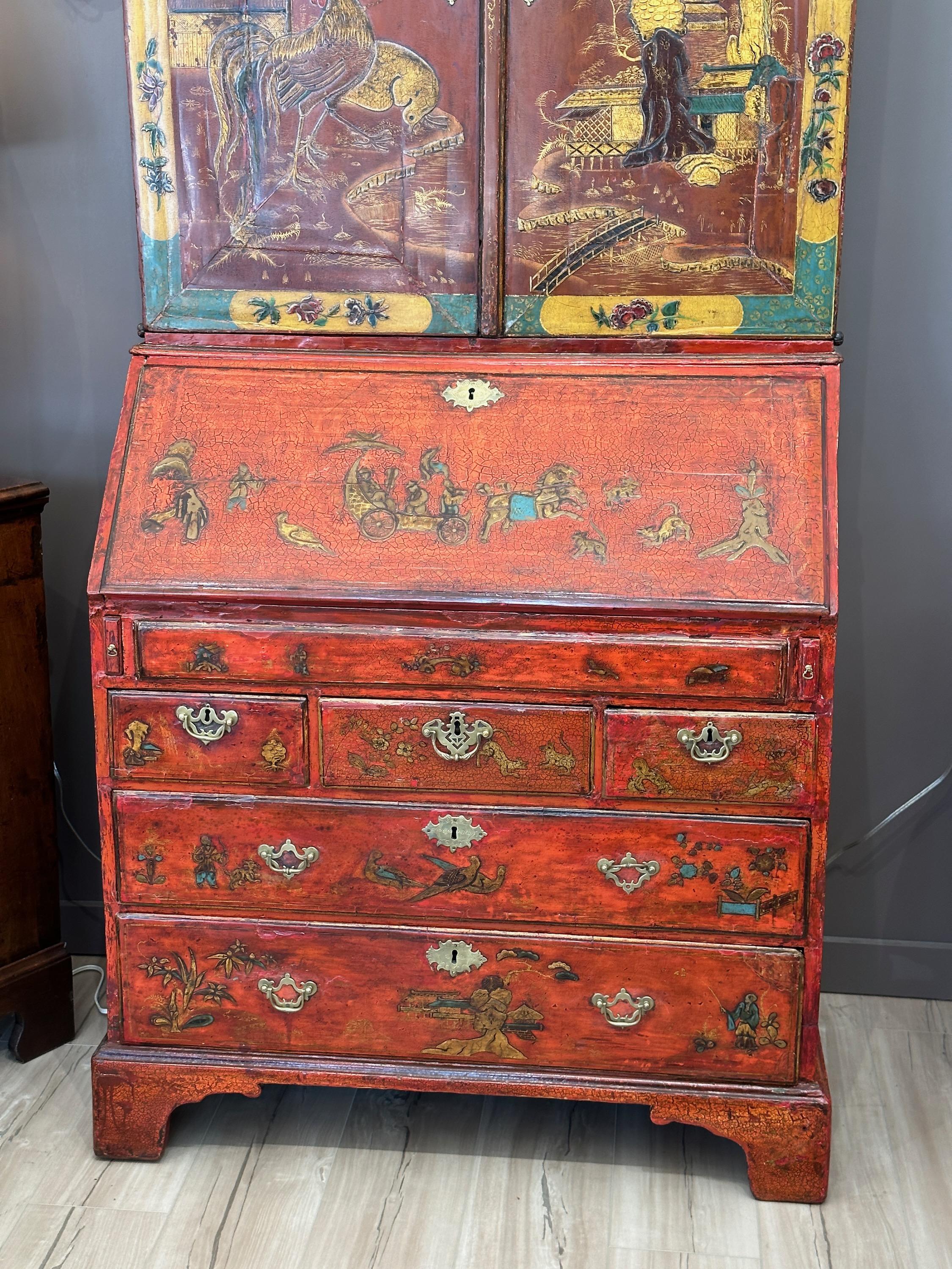 An elegant late 18th C. English scarlet lacquer and chinoiserie decorated blind-door secretary/bookcase with three shelves and three small drawers behind the doors above an extensively outfitted carved and decorated desk area with additional drawers