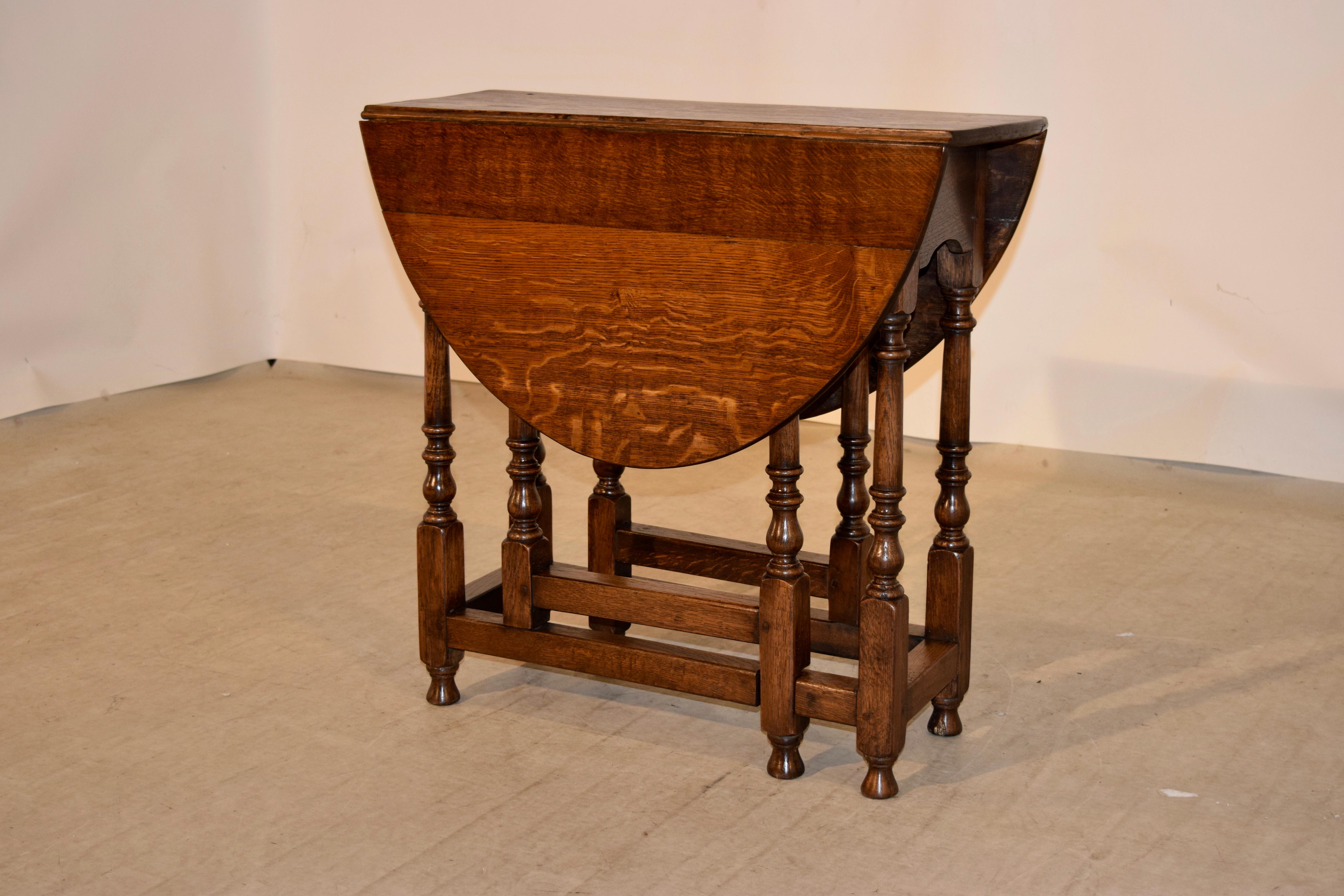 Late 18th century English oak gateleg table with a rounded edge around the top, following down to a single drawer on the end and hand-turned legs and gates, which are joined by stretchers and raised on hand-turned feet. Lovely hand pegged