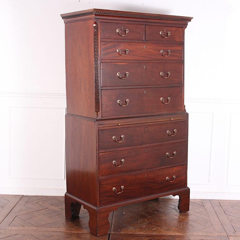 An English Georgian mahogany chest on chest, the top with two short drawers over three long, and with canted corners with blind fretwork carving, the base with ‘brushing slide’ over three long drawers, the whole standing on bold square bracket feet.