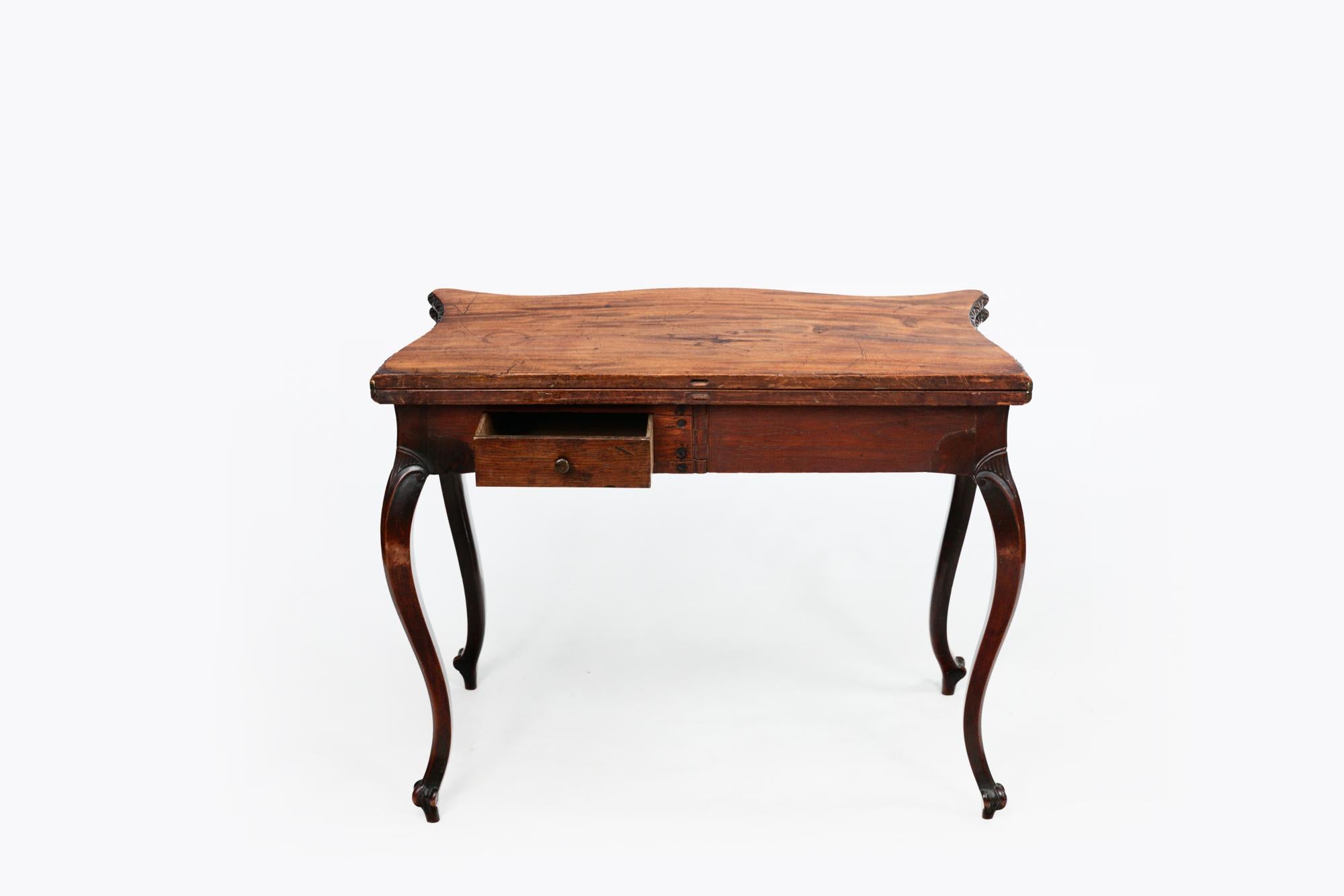Table à thé en acajou anglais de la fin du XVIIIe siècle à façade serpentine rabattable dans le style français de Foldes. Le plateau est orné de motifs floraux sculptés et est soutenu par des pieds cabriole avec genoux et pieds trilobés sculptés.
