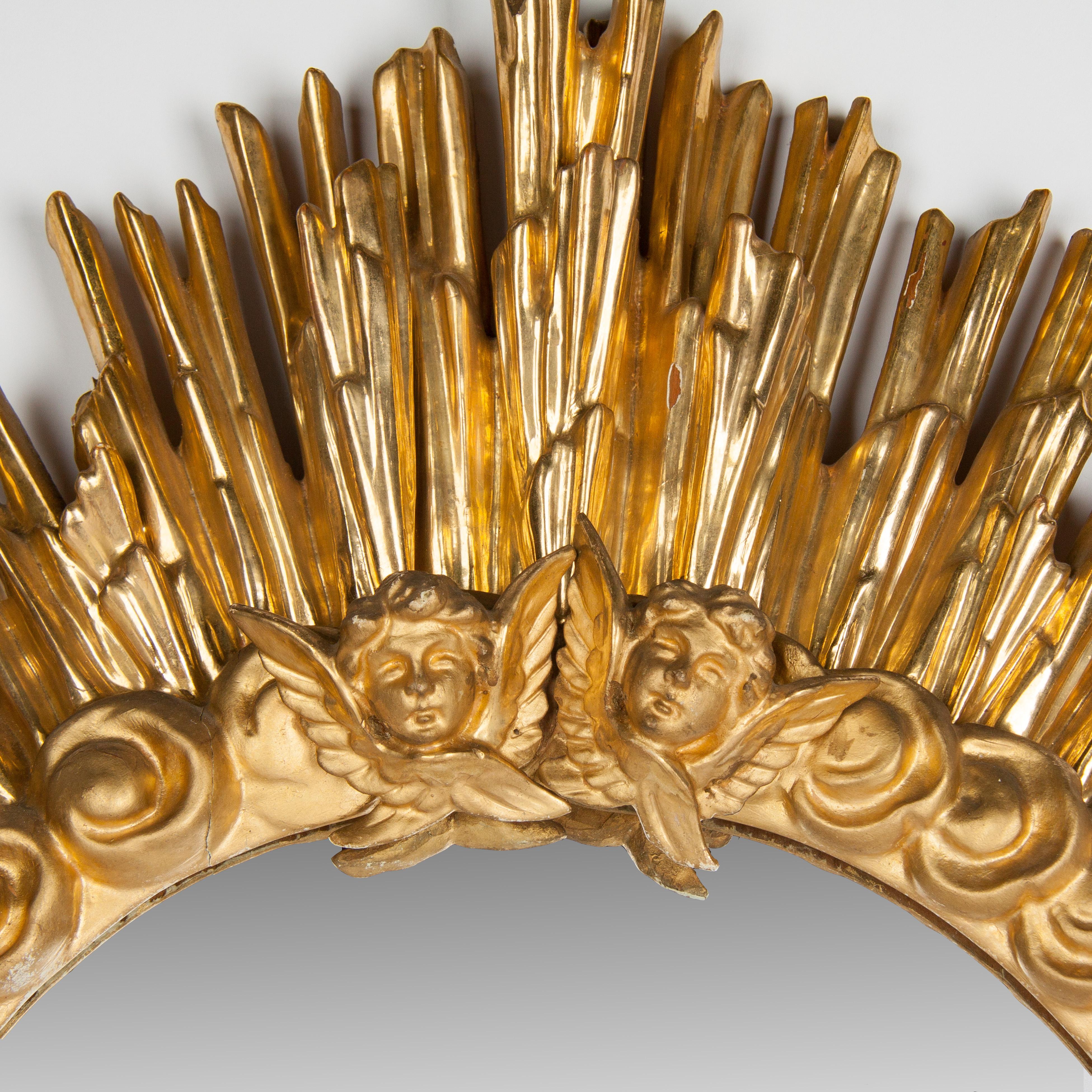Late 18th century wooden carved sun
burst mirror finely decorated with cherub angel heads.
Gold gilt and polychrome.