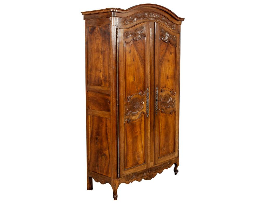 Late 18th century French armoire in Walnut. Exquisite original relief hand carved walnut armoire with original forged hardware including key, exceptional matching solid feathered walnut door panels, scrolled legs, interior has drawers and shelves.