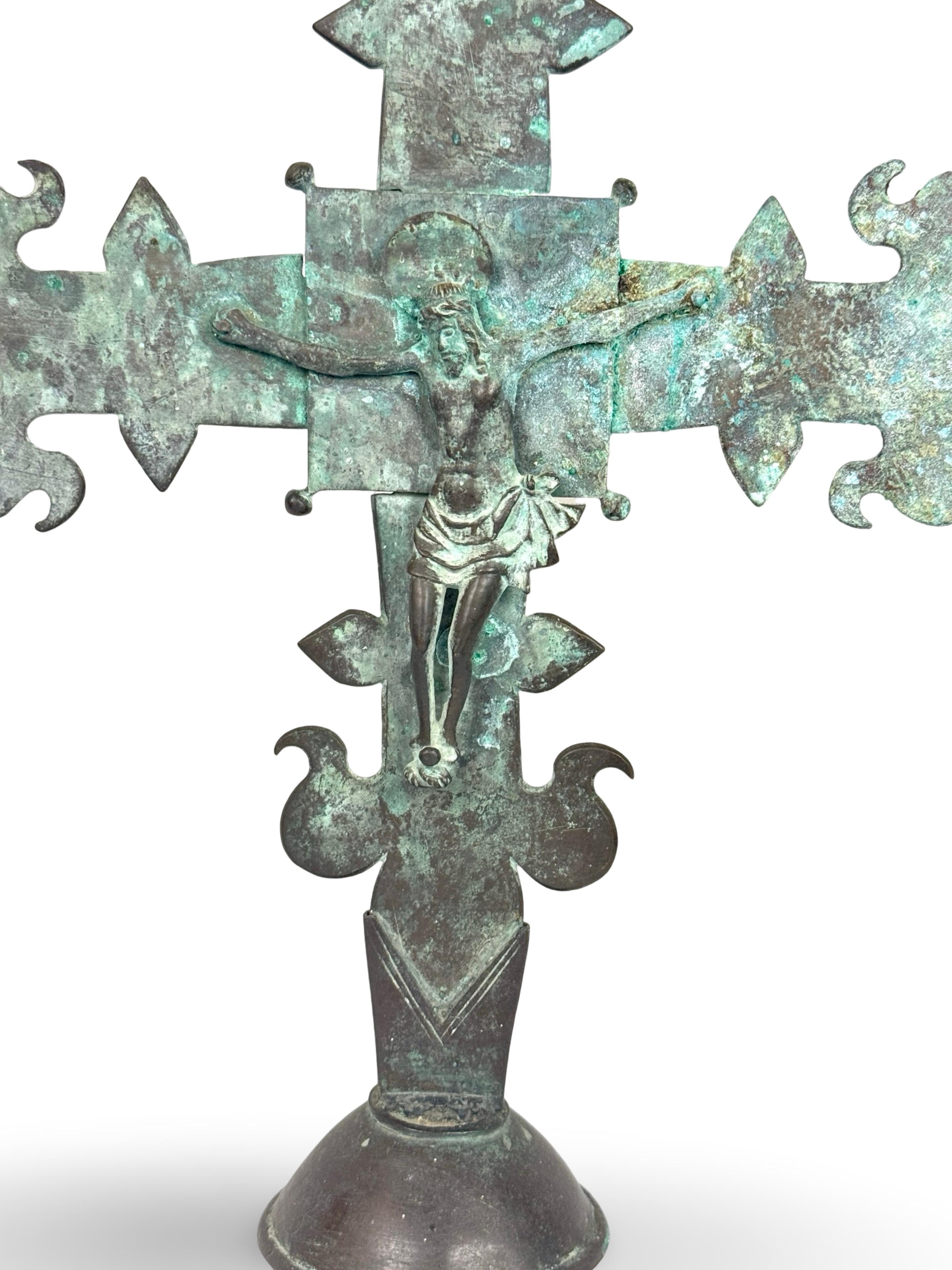 Una bellissima croce da processione in bronzo francese della fine del XVIII secolo, forse precedente. La figura di Cristo è unita con dei rivetti a una croce a forma di fiore di leone sollevata su un piede a cupola. La forma gotica e la variegata