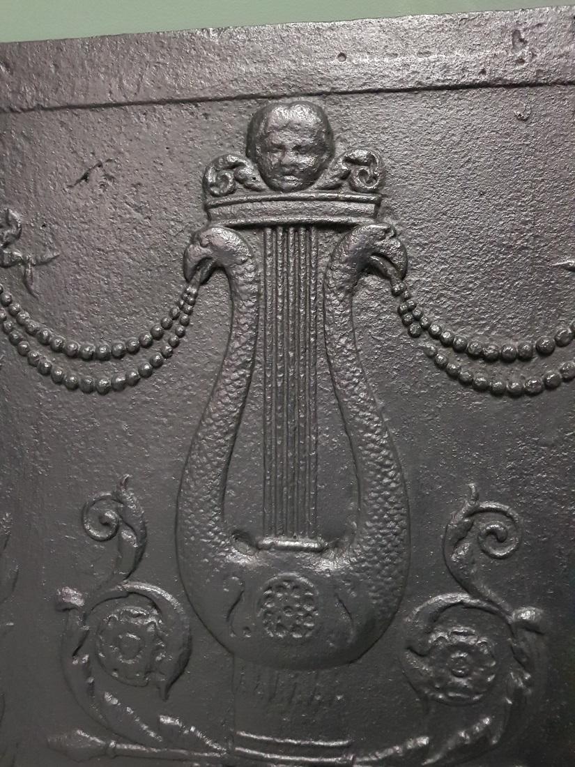 Antique French cast iron fireback from the Louis XVI period with the typical images such as a harp, bows, bird heads etc., this is also in a good but used condition. Originating from the end of the 18th century.

The measurements are,
Depth 1.5