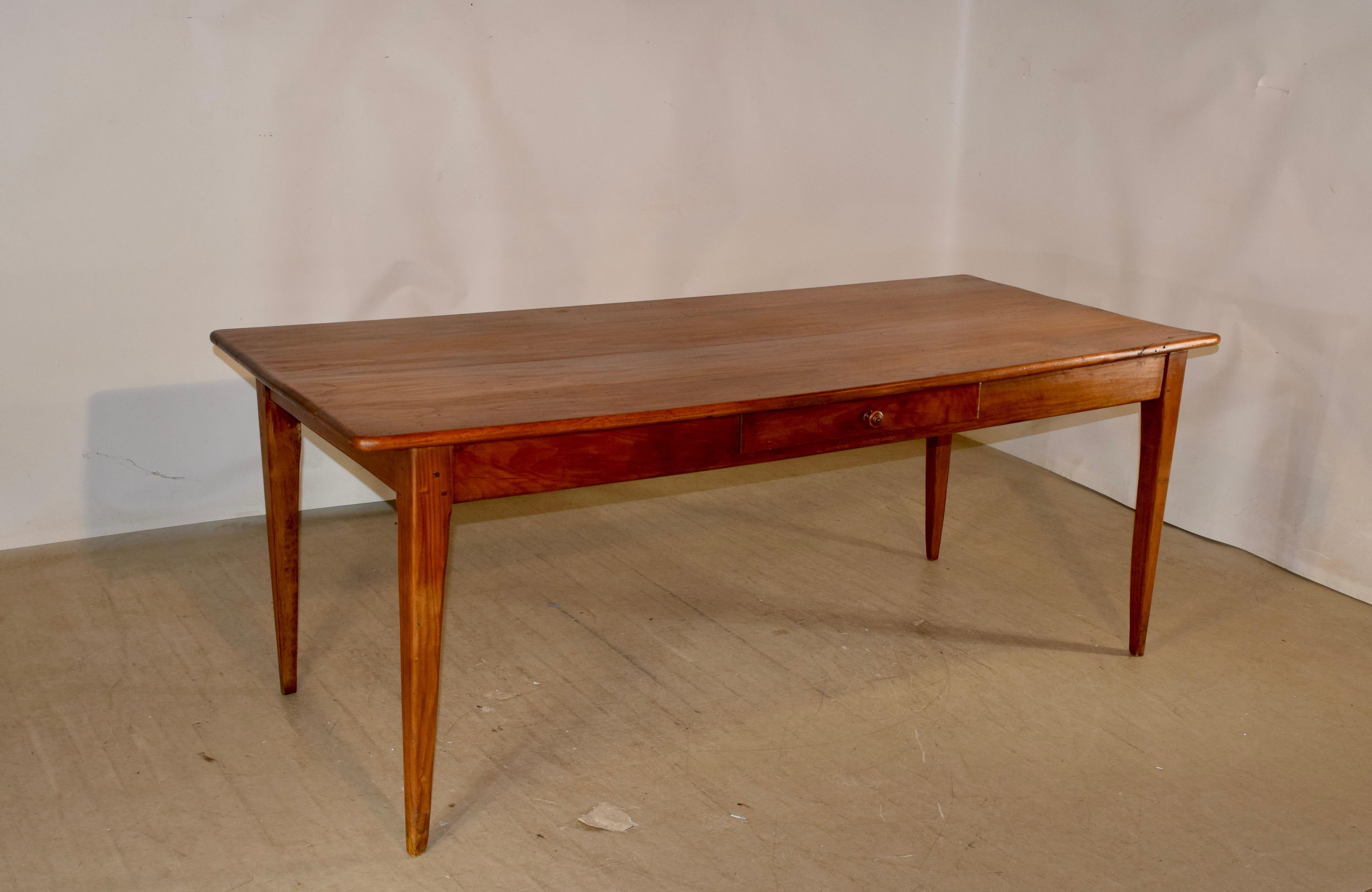 Late 18th century cherry farm table from France with a four plank top, which has marvelous graining and an old repair to one corner which is very sturdy. The apron is simple and contains a single drawer on one side, and the table is supported on