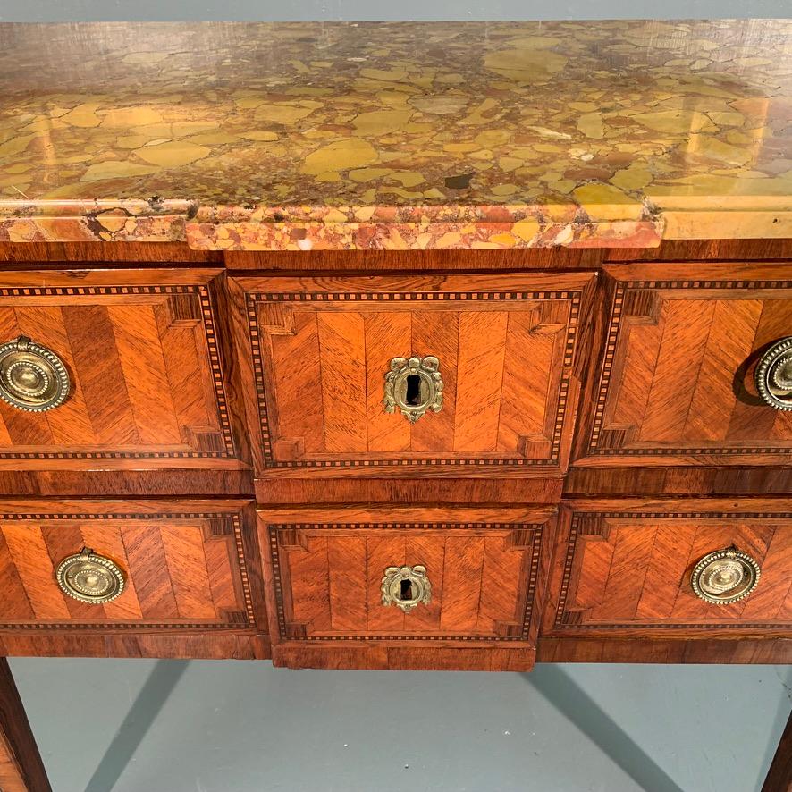 A lovely early 19th century French Louis XVI period 3/4 size two drawer commode chest of drawers with its original breakfront marble top, matching the breakfront of the two drawer front, circa 1780.
Beautifully finished with the chevroned marquetry