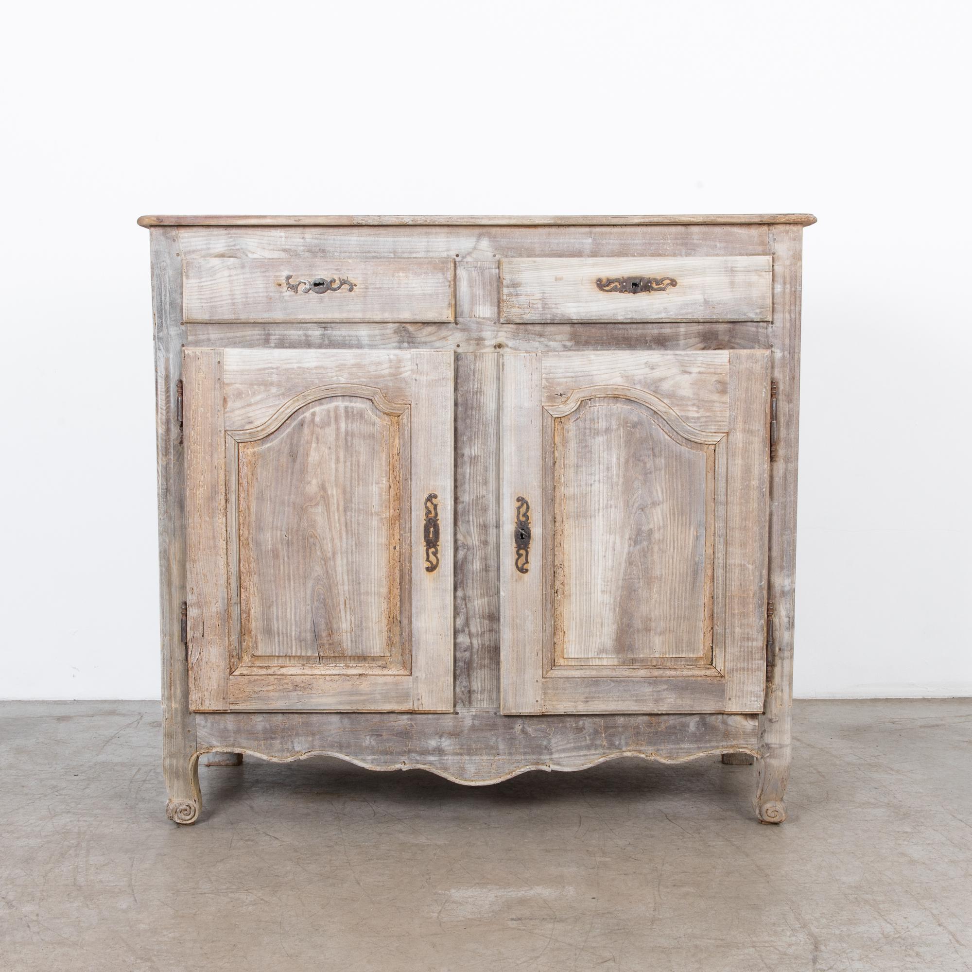 From late 18th century France, a two-door and drawer cabinet in elmwood. A distinctly country style approach typifies the casual yet refined aesthetic of the French countryside. A beautiful rustic finish shows evidence of wear, the seasoning of time