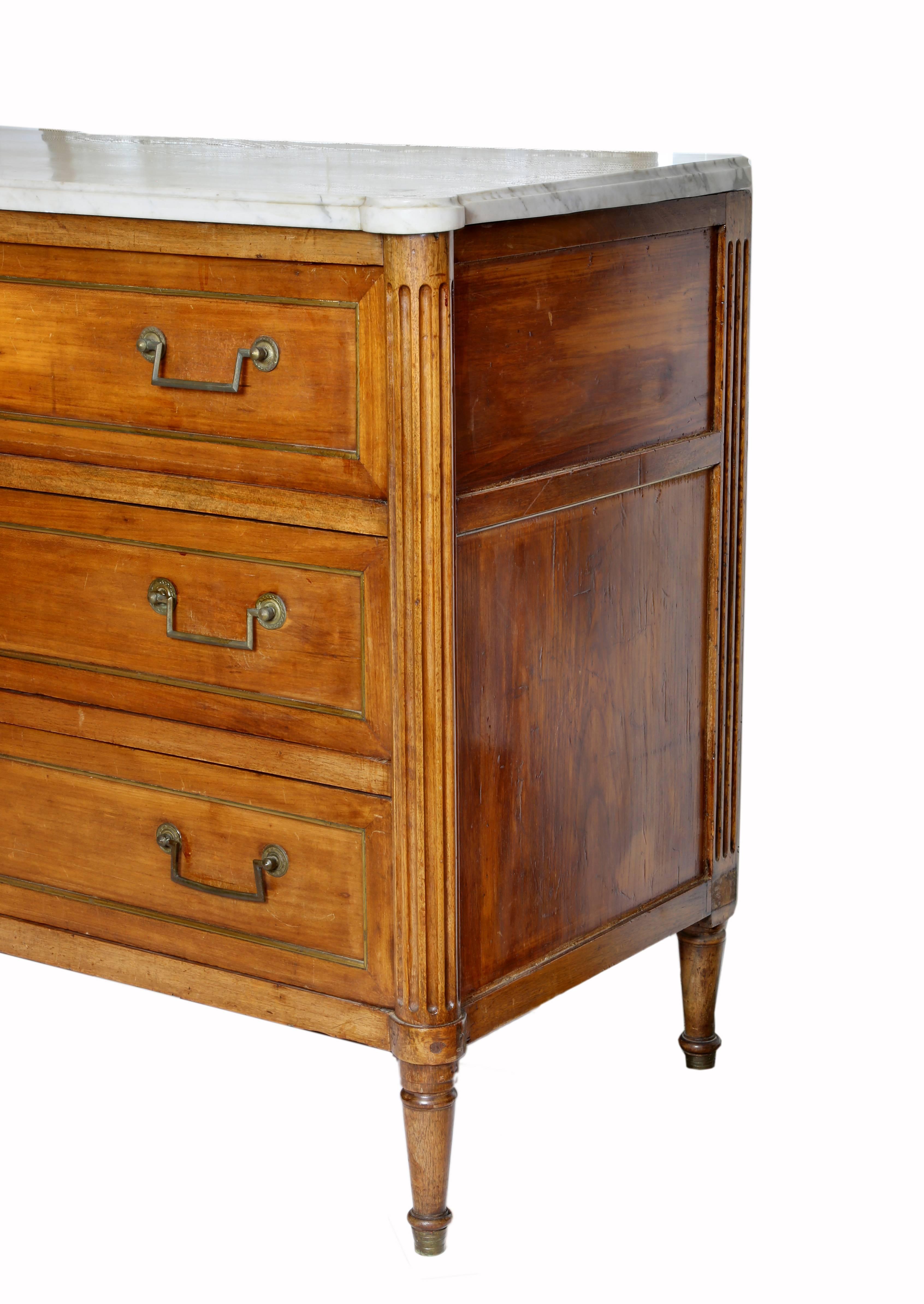 Directoire style commode or buffet in cherrywood with a shaped marble top over
a conforming body. The sides are fluted and the piece is fitted with three drawers rising on turned tapered legs.