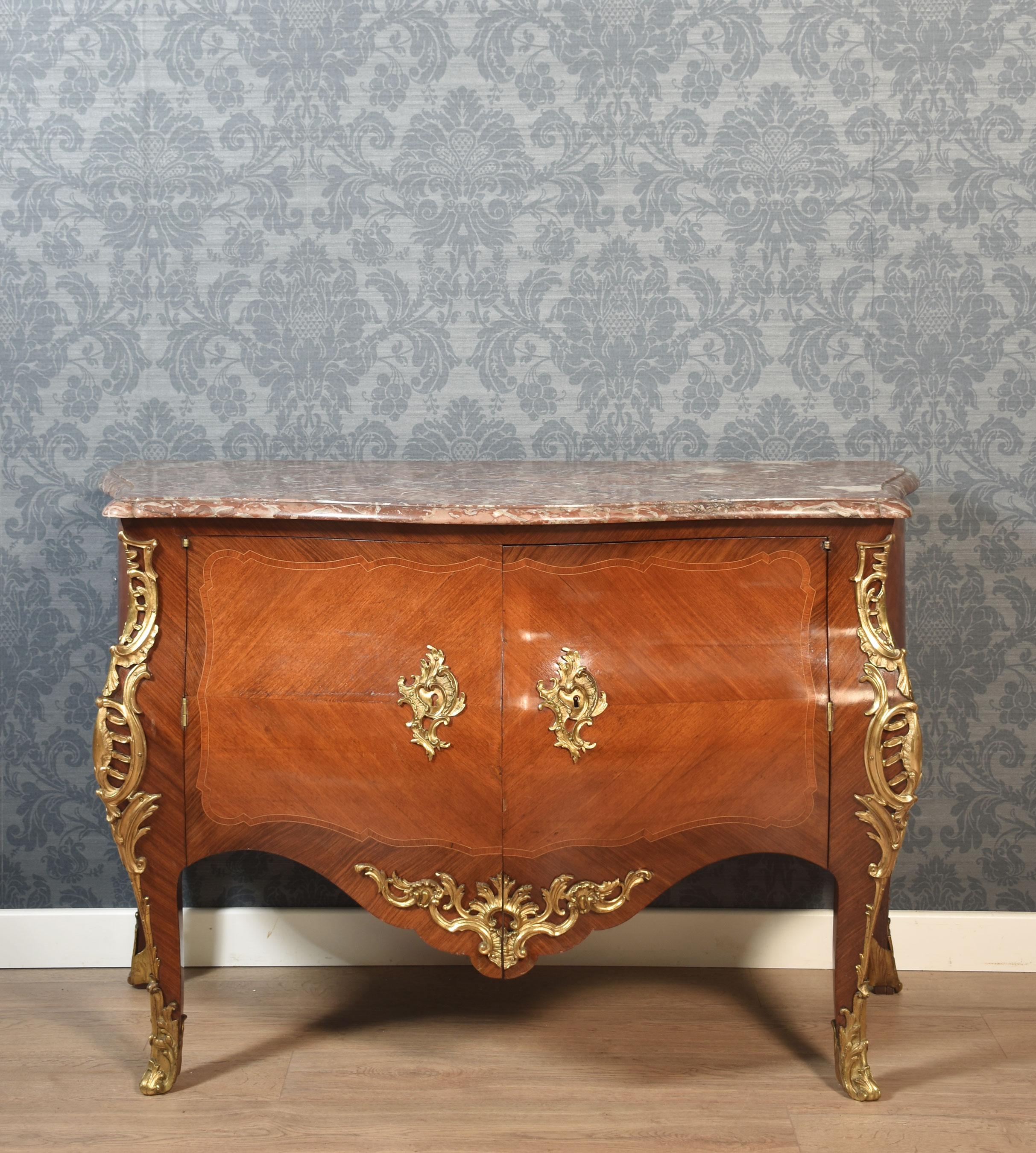 Commodo a forma di bombe in noce con montatura in bronzo dorato della fine del XVIII secolo. Con un piano in marmo broccatello spagnolo modellato sopra una coppia di ante rivestite a quarti, che si aprono per rivelare due cassetti corti e uno lungo.