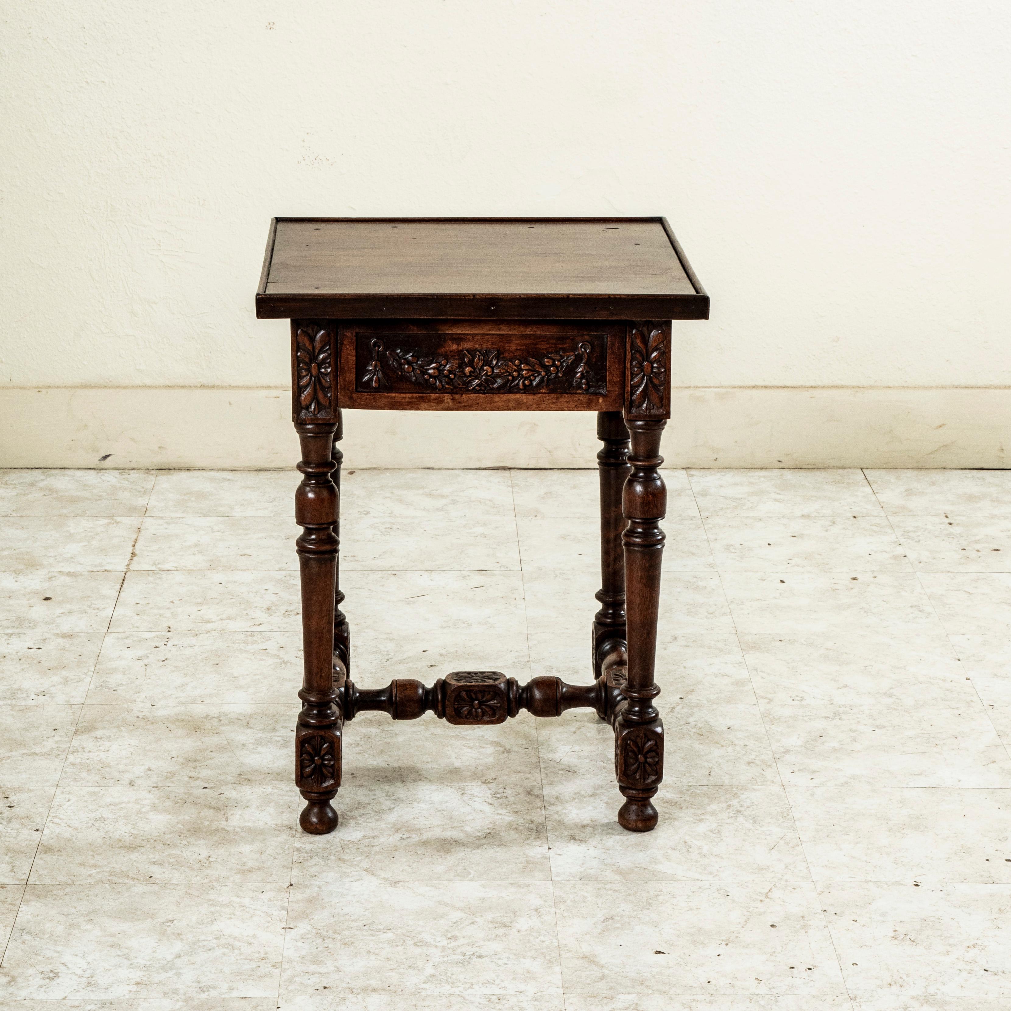 Cette table d'appoint carrée de la fin du XVIIIe siècle, d'époque Louis XVI, présente des rosettes sculptées à la main sur les joints d'emboîtement et des guirlandes qui détaillent chaque côté du tablier. Un tiroir à queue d'aronde s'intègre