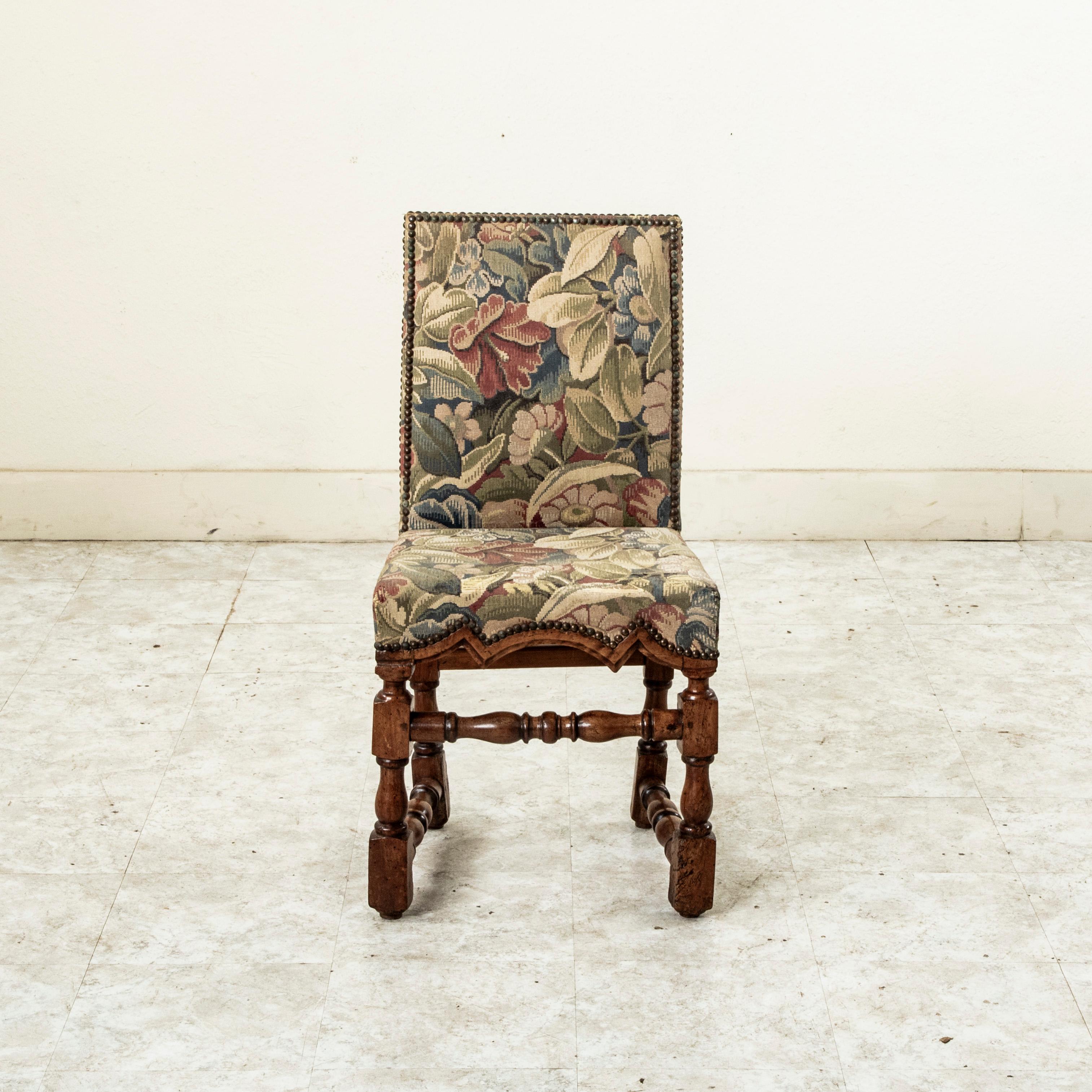 Questa poltrona in noce francese del XVIII secolo è costruita con un sistema di incastri a mortasa e tenone e presenta un grembiule intagliato a mano. La sedia poggia su gambe tornite a mano unite da supporti torniti che ne garantiscono la