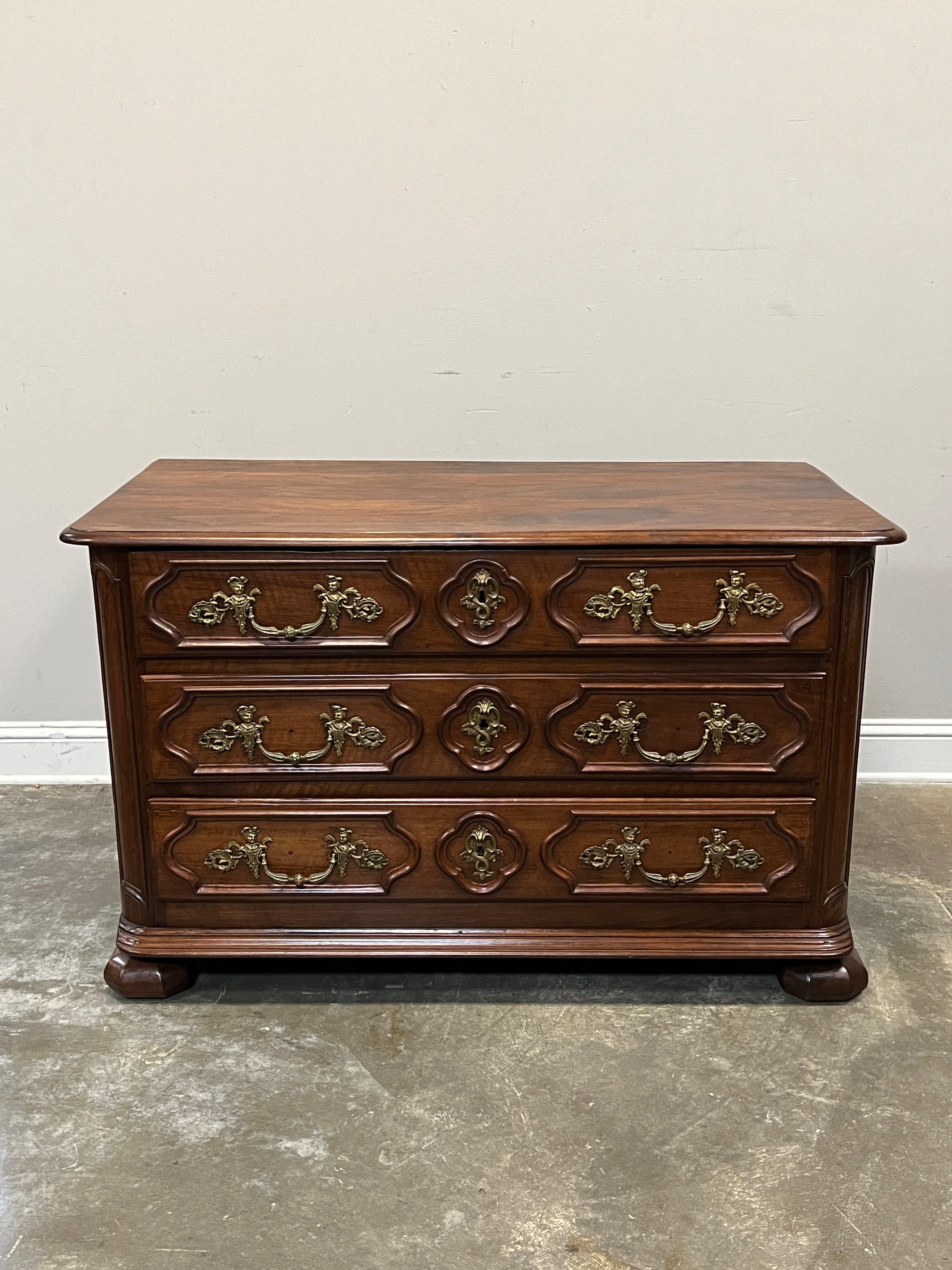 Generously sized French walnut commode in a transition style from the earlier Louis XIII and Louis XIV style with heavier look, bun feet to the lighter style of Louis XV with decorated drawer fronts. Drawers exhibit the lozenge shapes common to