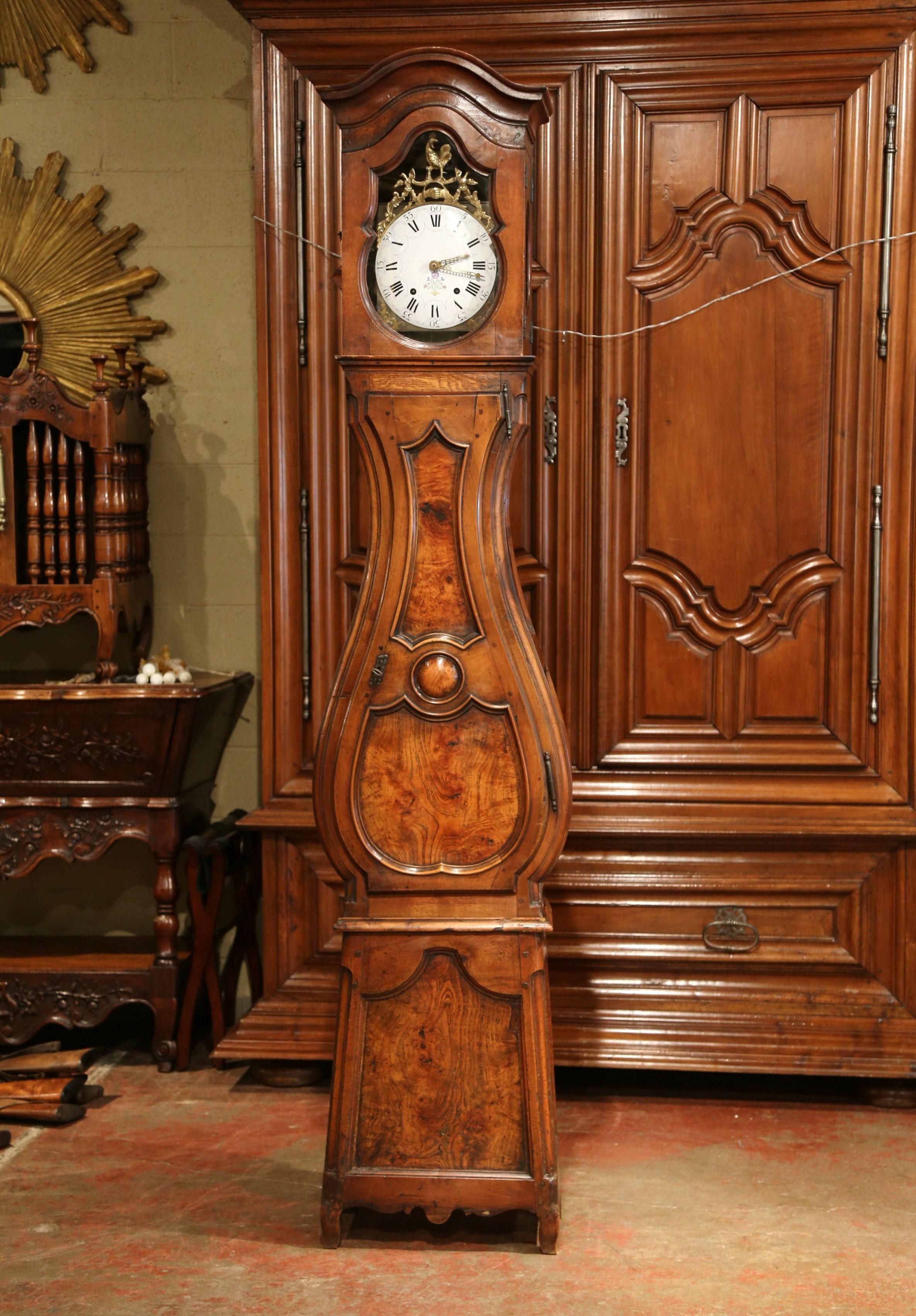 This elegant, antique grand father clock was crafted in Lyon, France, circa 1780. The fruitwood tall case clock has beautiful carved lines with a bonnet top, a violin shape body style and finished at the base with scroll feet under a scalloped
