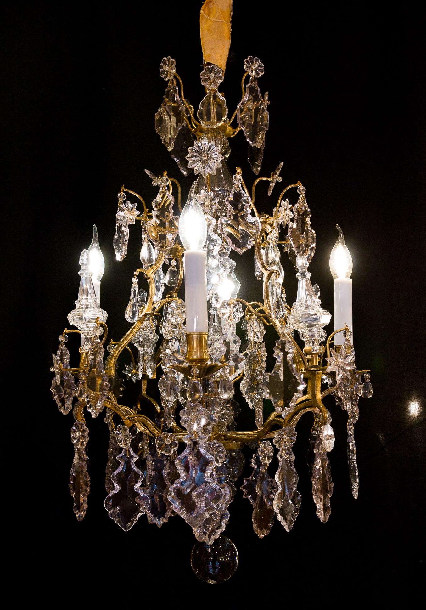 We are pleased to present you, beautiful ormolu and hand-cut crystal, chandelier in the classic Louis XV style. 
Our chandelier is composed of four perimeter arm lights. 
Excellent quality white hand-cut crystal pieces, plaques, four peripheric