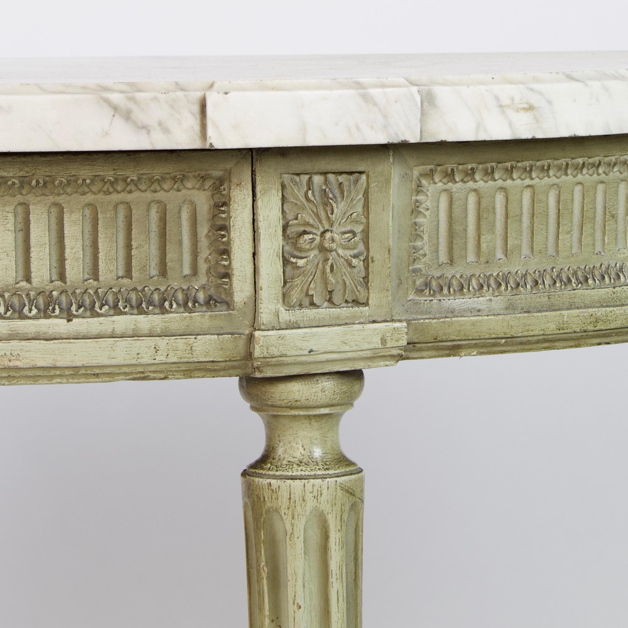Late 18th century French Louis XVI carved and painted wood demilune console table

The demilune moulded mottled white and grey marble top above a carved frieze with fluting, lesbian kyma and square paterae. Standing on four fluted and tapering