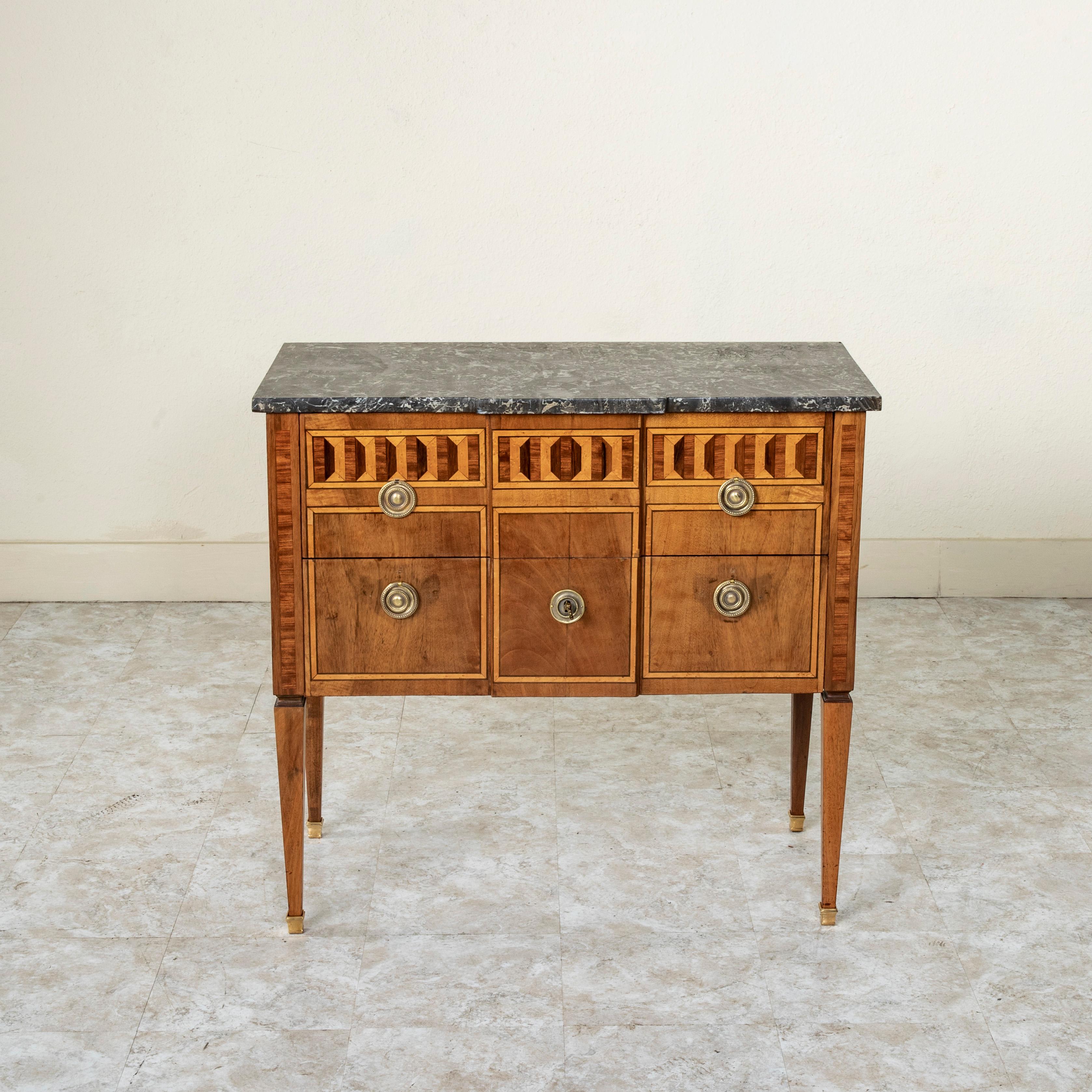 Found in the region of Normandy, France, this rare smaller scale late eighteenth century Louis XVI period sauteuse chest features a geometric marquetry facade of rosewood, lemon wood, sycamore and palisander on three sides, and is crowned with a