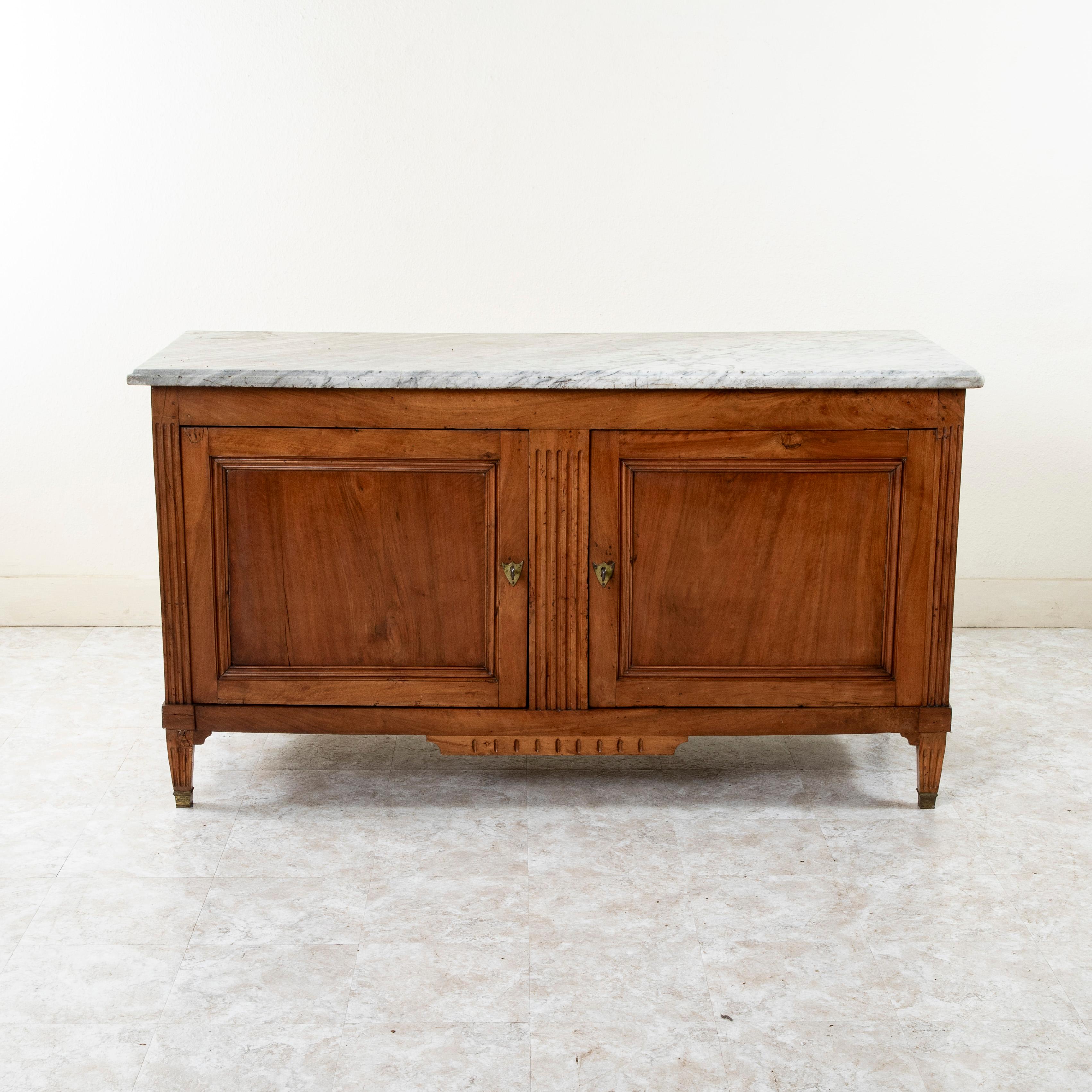 Found in Aix-en-Provence in southern France, this late eighteenth century Louis XVI period walnut hunt buffet features its original beveled marble top. Originally used in a hunting lodge where game was placed after the hunt, this buffet  is detailed