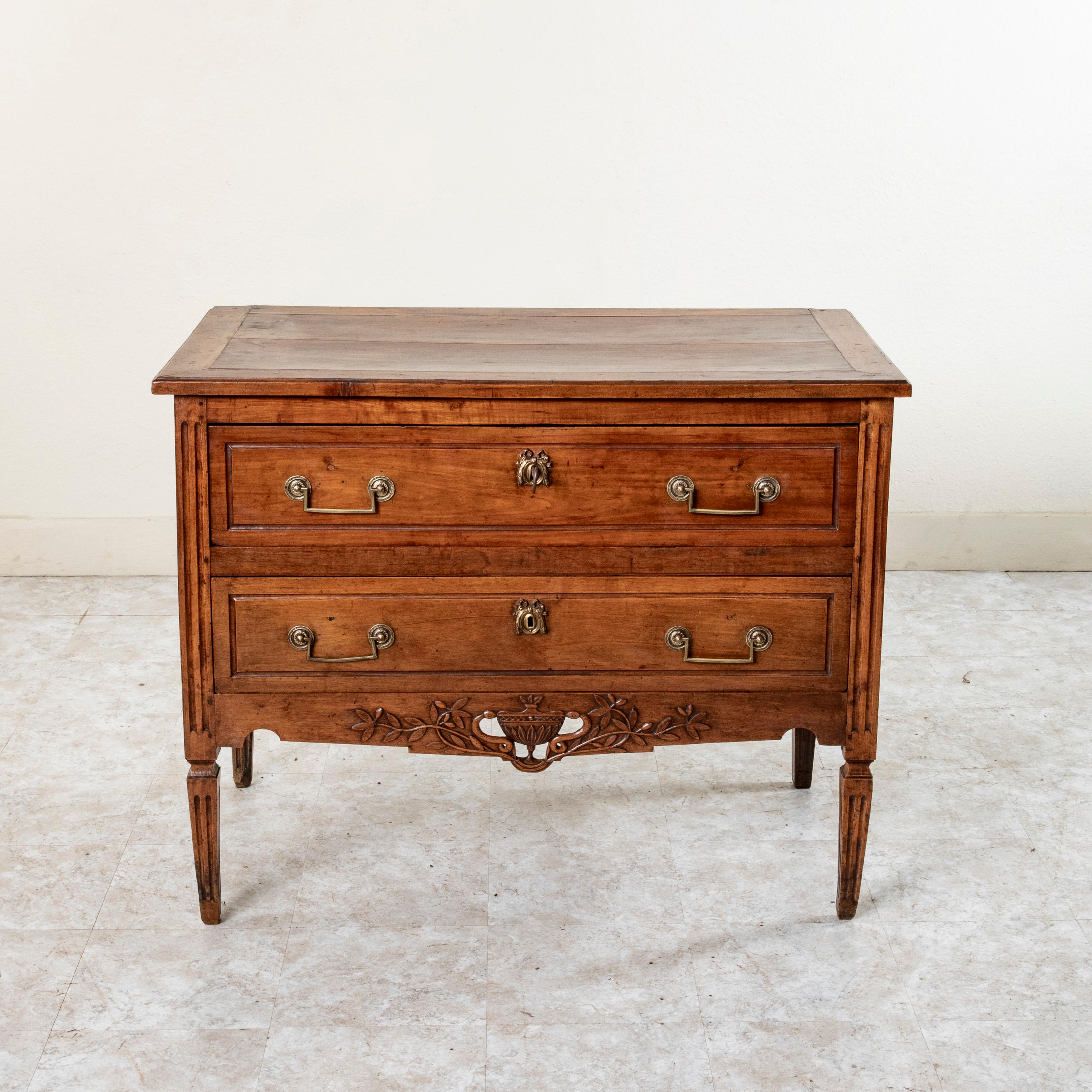 Found in the region of Languedoc in the south of France, this late eighteenth century Louis XVI period commode or chest of drawers is constructed of  walnut, cherry wood, and chestnut. With a hand pegged top and paneled sides, this piece features a