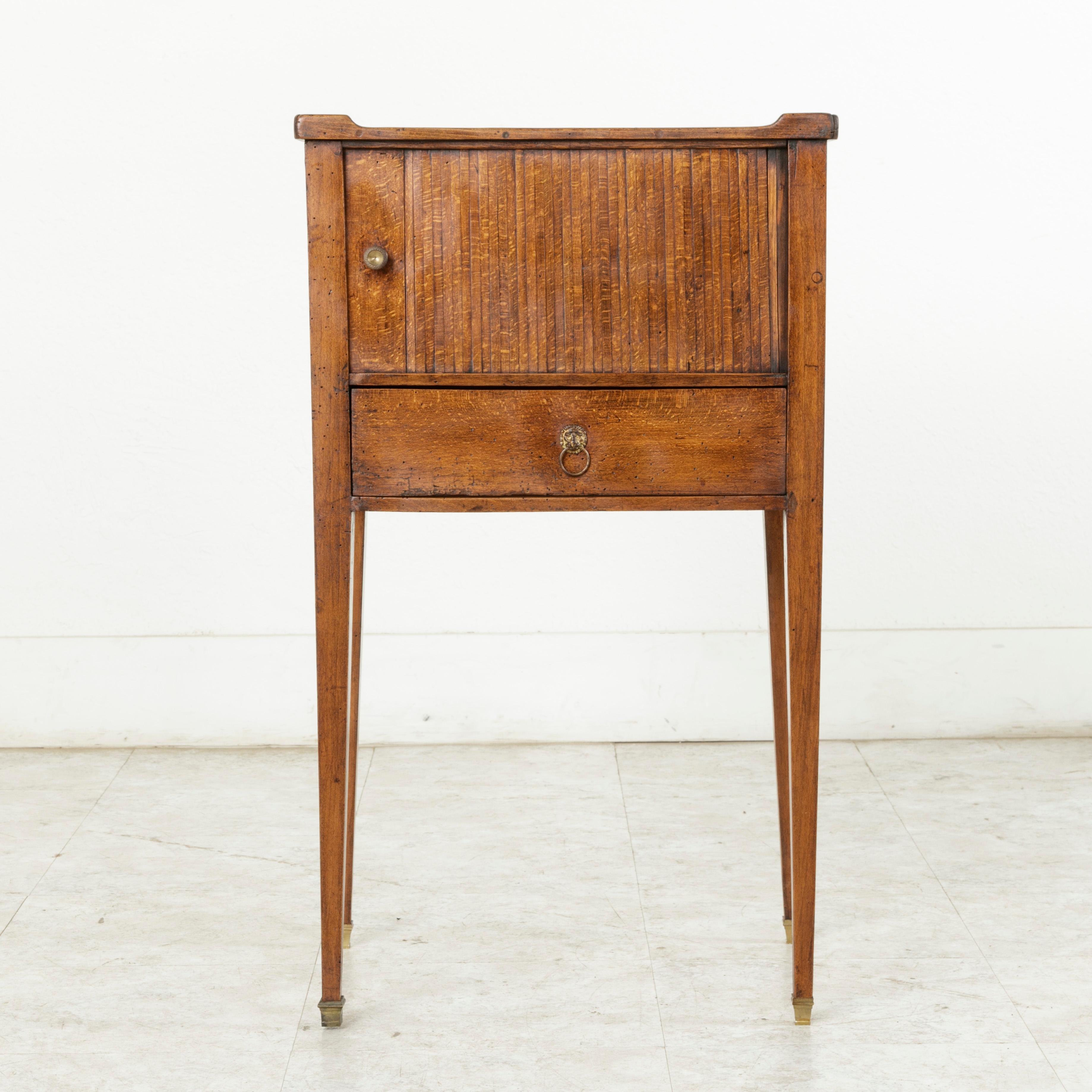 This 18th century French Louis XVI period walnut nightstand or side table features a sliding door referred to as a curtain or Rideau in French. The sliding door allows for access to its interior compartment. A single drawer of dovetail construction