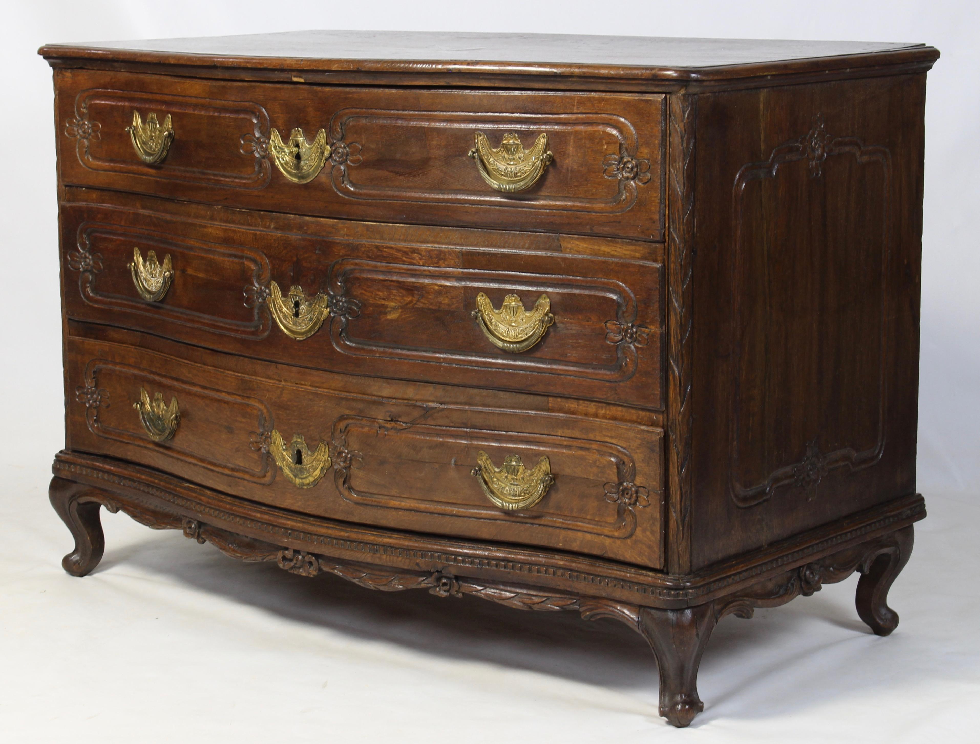 An elegant late 18th century serpentine front commode with marquetry top, three graduated drawers with original pulls resting on carved cabriole legs.
