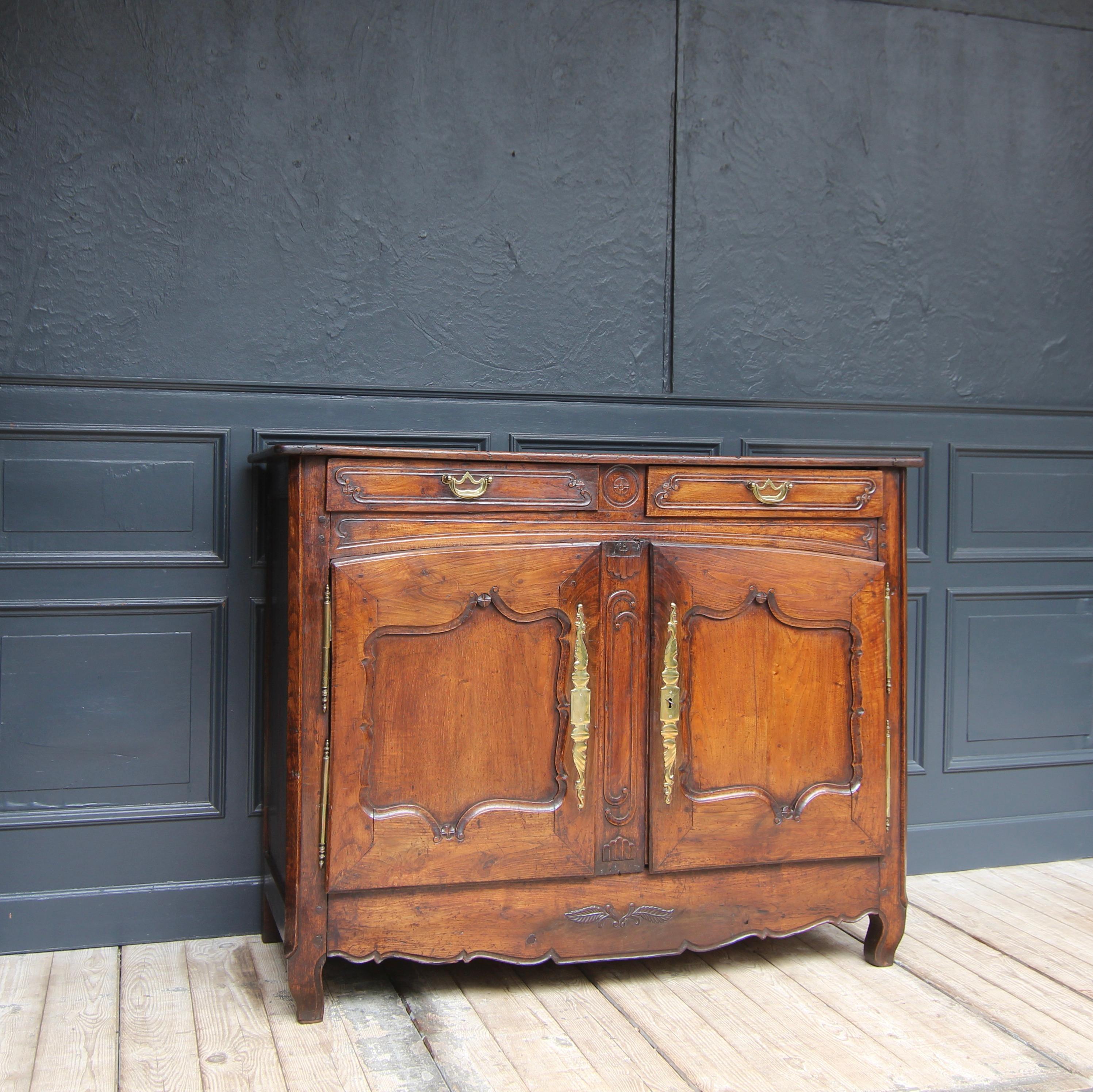 A French provincial sideboard from the late 18th century. Made of solid oak wood with beautiful, warm patina.

Partially ornamentally carved oak body, panelled on the sides, and with 2 drawers under a slightly protruding top panel. Bevelled corners