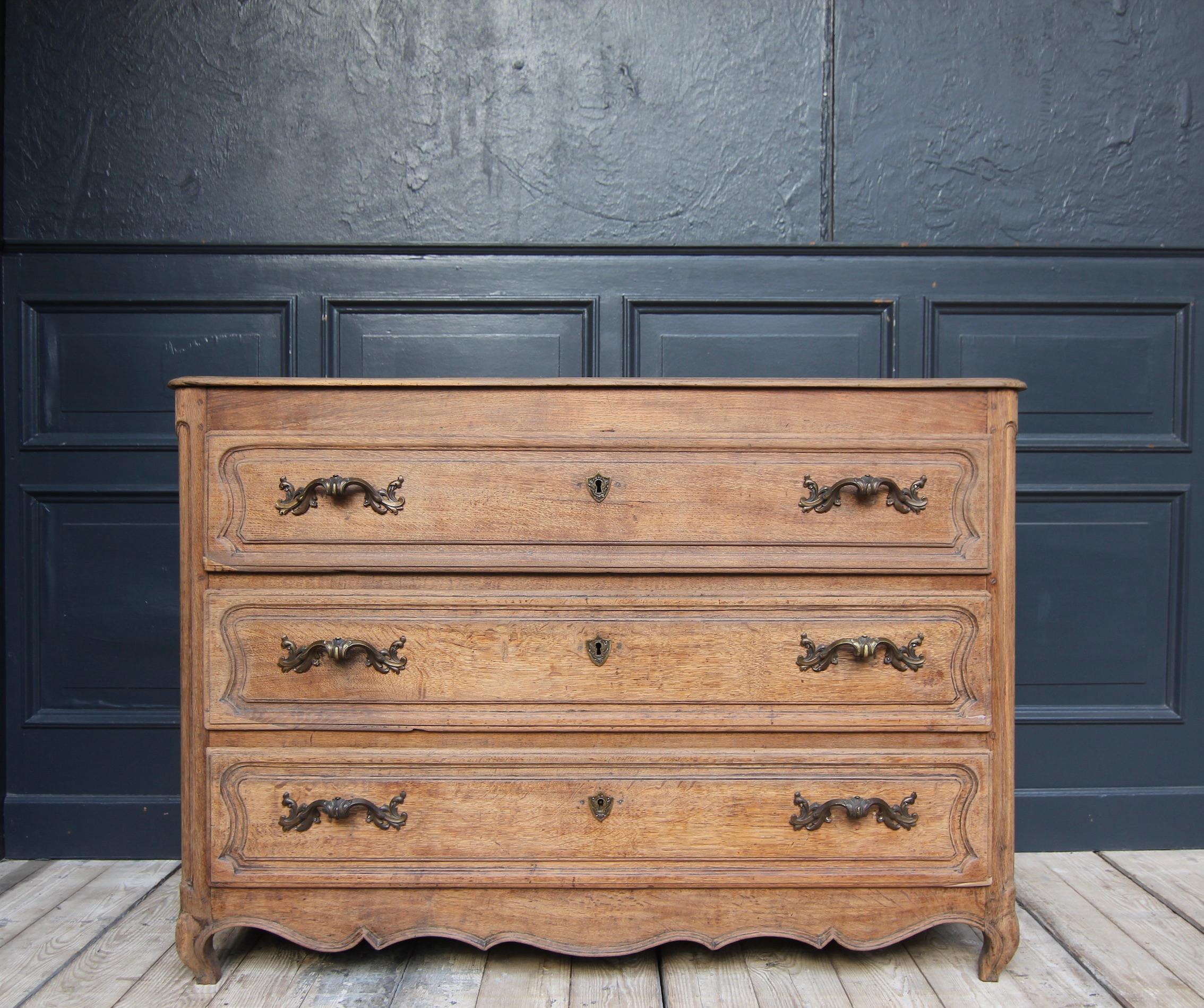 French provincial chest of drawers from the 2nd half of the 18th century. Solidly made of oak wood and carved.

Three-bay corpus with coffered sides and slightly overhanging profiled top plate. Rounded pilaster strips and drawer fronts carved with