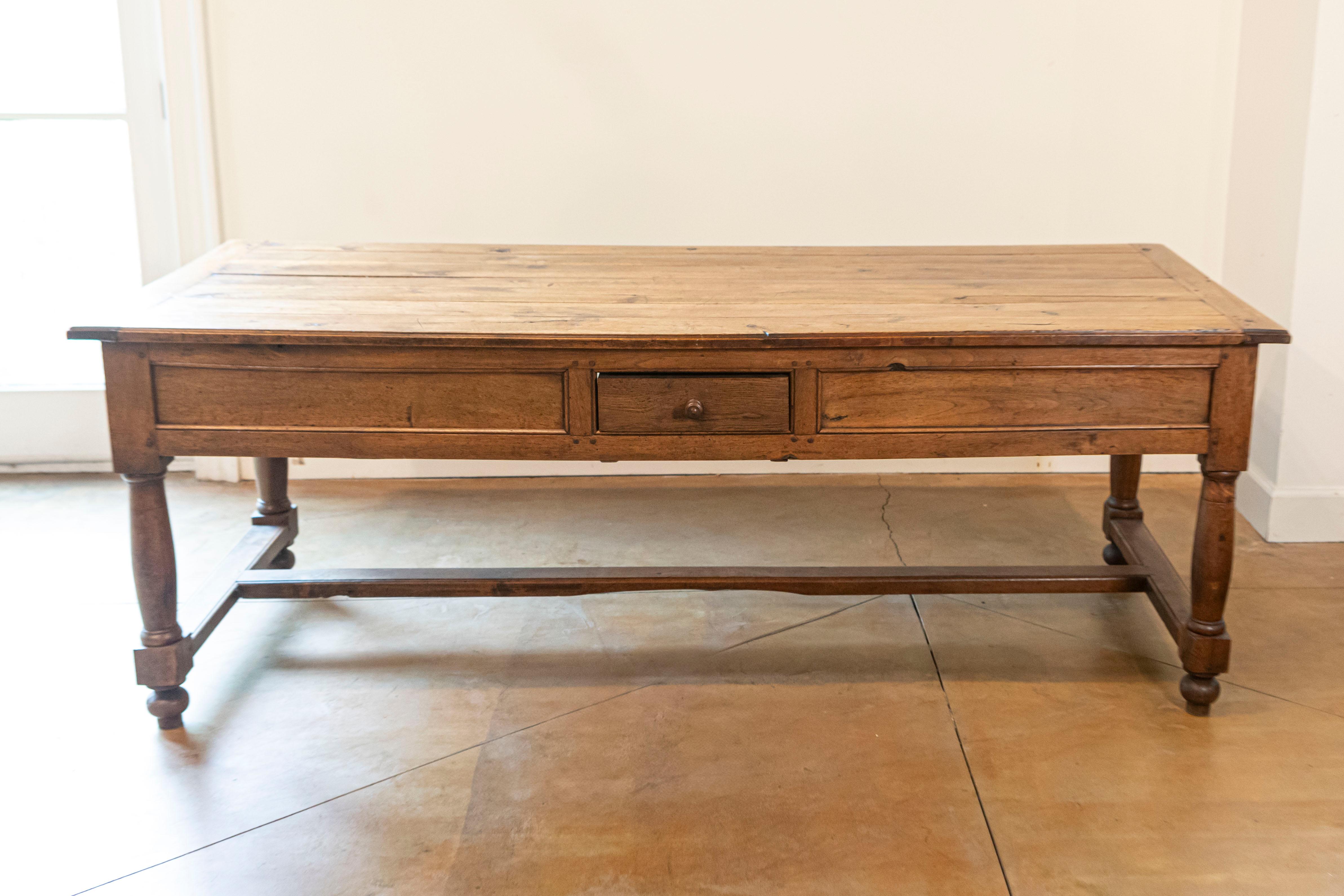 Mesa de sofá francesa de nogal y madera de acacia con cuatro cajones, patas torneadas y cruceta de finales del siglo XVIII. Nacida en los últimos años del reinado del rey Luis XVI, esta mesa de sofá francesa presenta un tablero rectangular