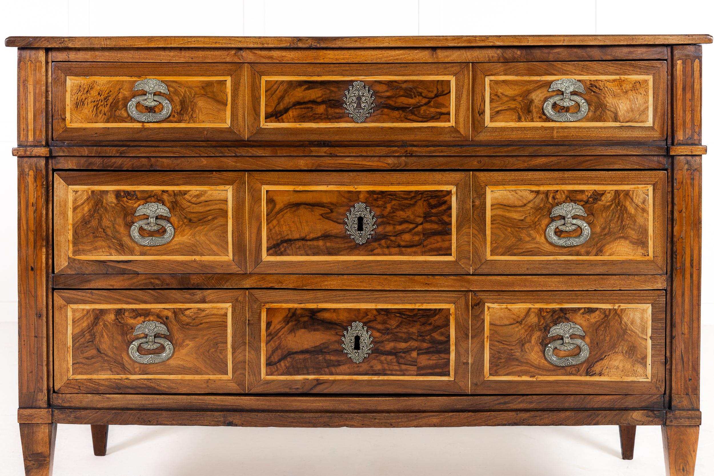 An Attractive Late 18th Century French Provincial Louis XVI Walnut Commode.

Standing on tapering square sectioned feet, and is of typical Louis XVI rectilinear form, its straight lines contrasting beautifully with the curly veneers of the burr