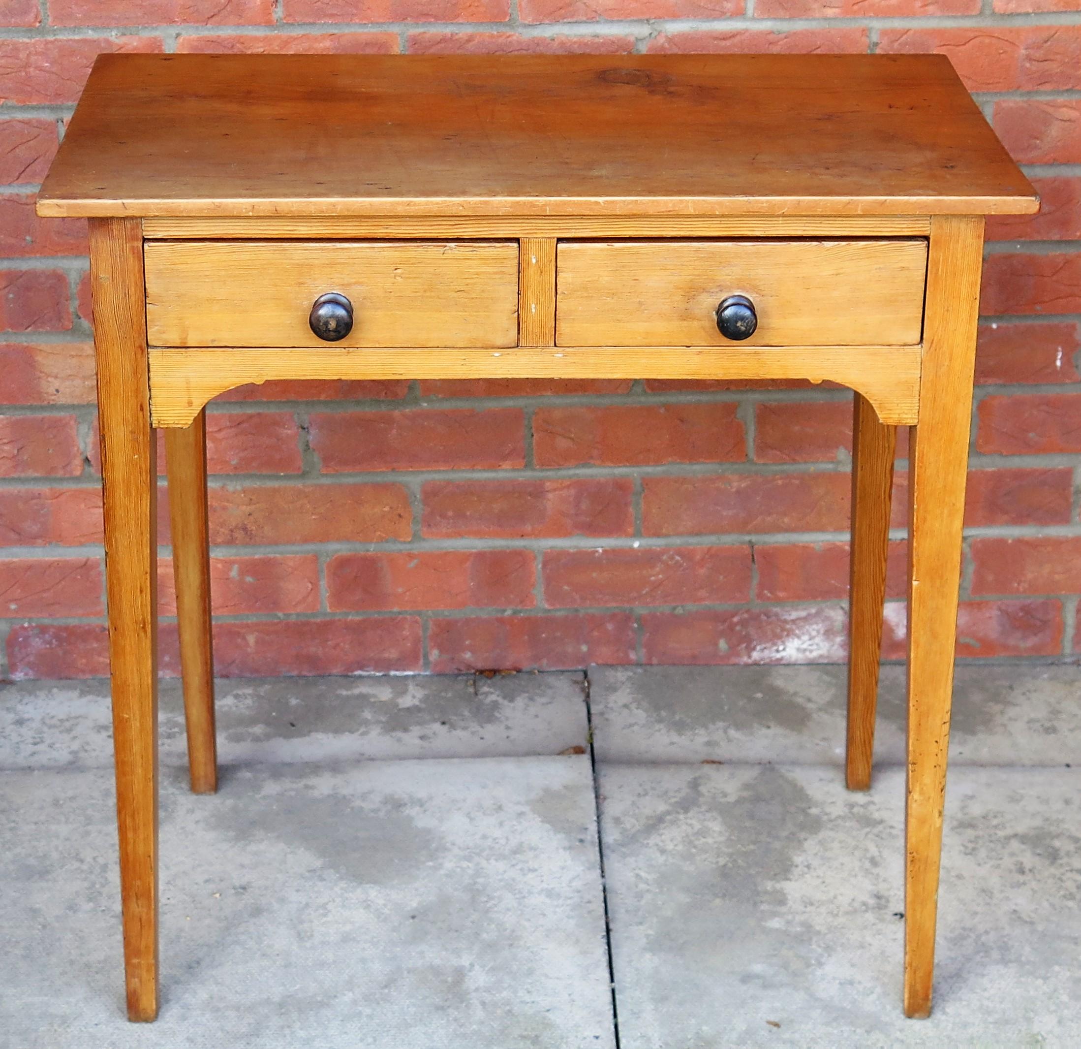 This is a well made solid pine side table with two drawers, dating to the English George III period of the late 18th century, circa 1790.

This is a lovely Georgian piece of English country furniture with great small proportions

The one piece top