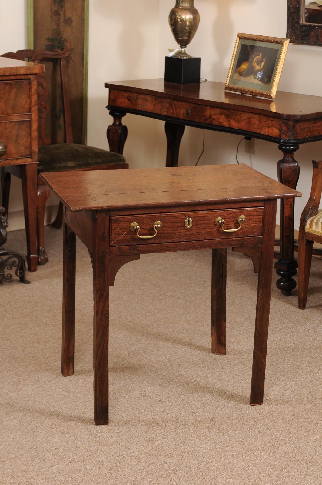 The late 18th century English George III oak side table with 1-drawer, side fretwork brackets and square legs.