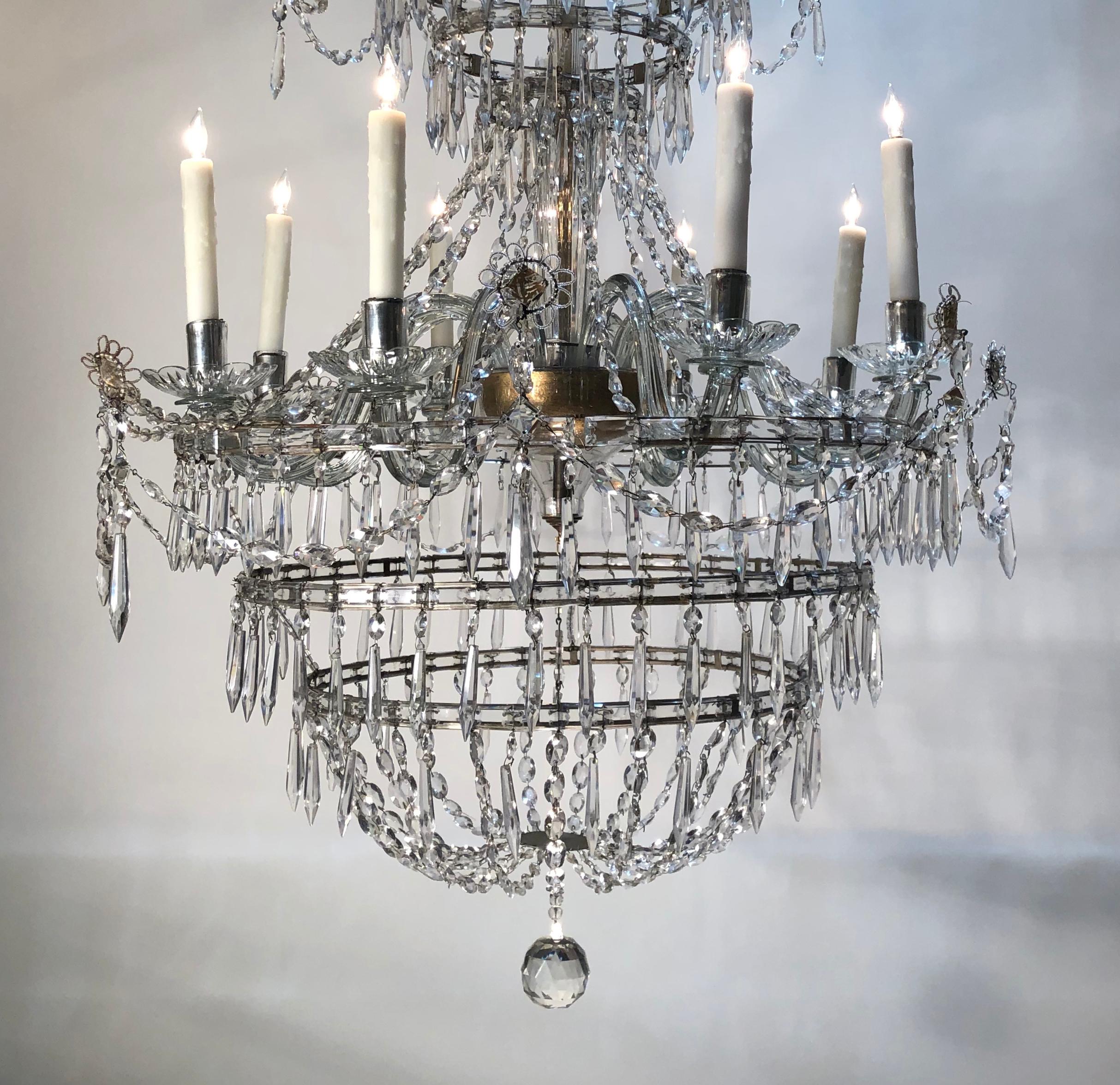Rare late 18th century Georgian crystal eight-arm chandelier, originally candle. This stunning chandelier is English and of the neoclassical period. The eight crystal candle branches are encased in a crystal beaded frame. This exceptional chandelier
