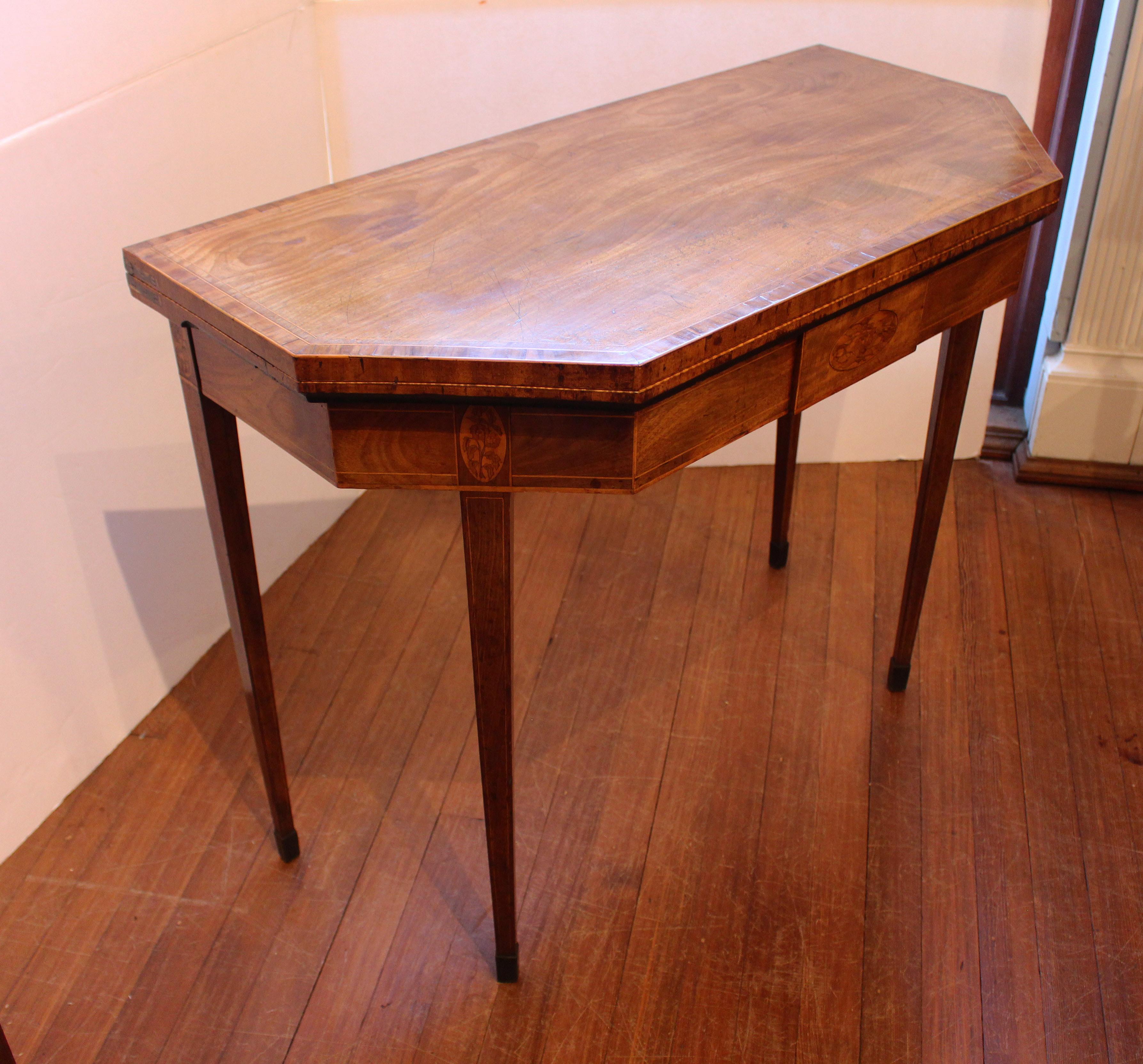 Late 18th century Georgian inlaid fold-top card table, English. Interesting canted corner form opens to a hexagonal shape. The leg placement at the mid-point of the canted sides allows for greater seating space, as does the double-gate leg