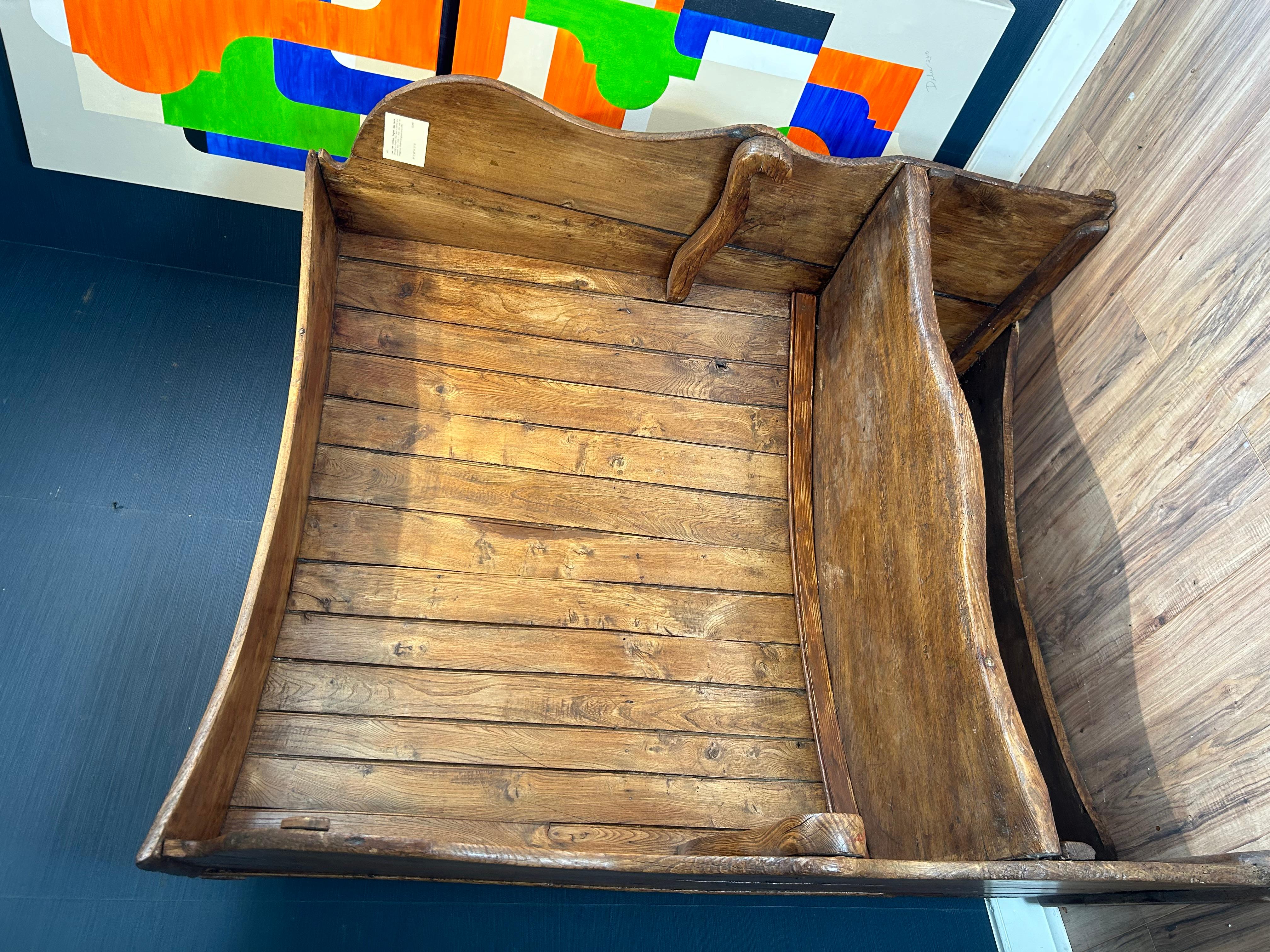Late 18th Century Georgian Elm Settle. Designed to avoid the wintry drafts. Decorative shaped ends with a curved and paneled back over a thick elm seat on sledge feet. Typically used in an entrance hall or beside an 