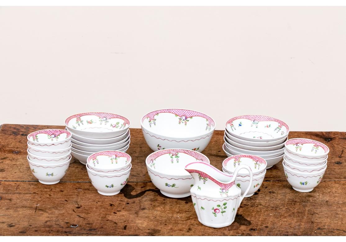 Late 18th century Georgian English New Hall partial fine porcelain tea/china set with rose colored fish-scale border, scrolling garland and florets, circa 1781-1835. Included in this service:

Large footed slop bowl, 6