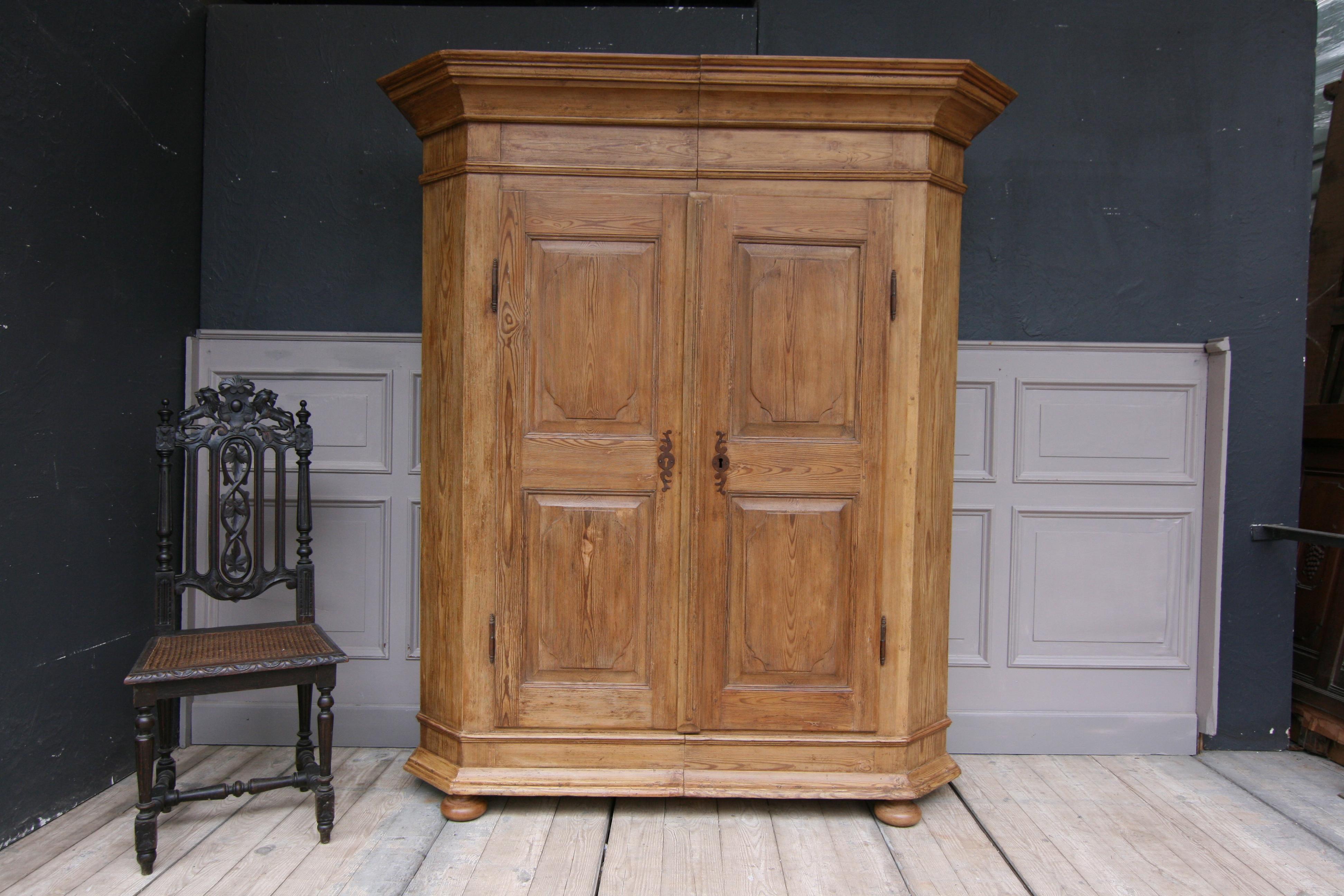 Late 18th century German Provincial Baroque cabinet made of solid pine. Restored and waxed.

2-parted body can be split by means of a wedge connection. Bevelled corners. 2 doors on outside hinges. Original hand forged fittings, hinges and bolts
